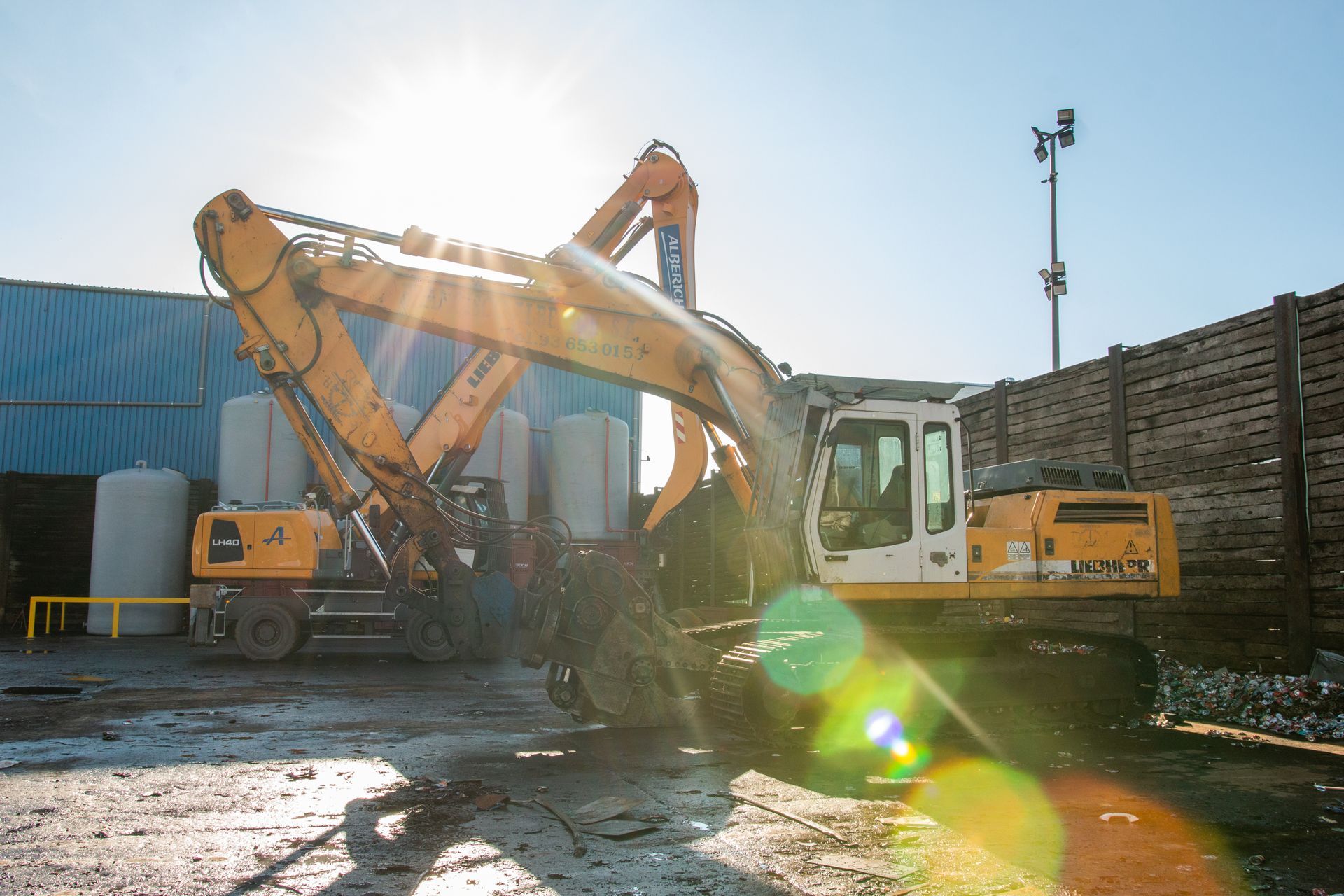 A large yellow excavator is parked in front of a building.
