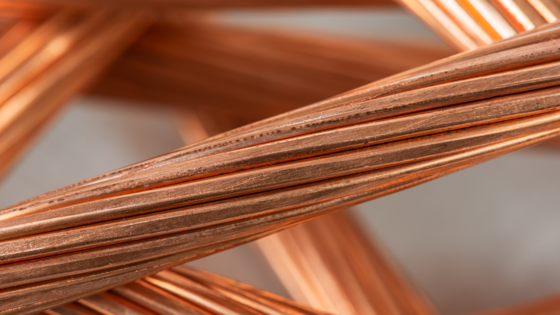 Copper wire strands twisted together, close-up showing the metallic texture and reddish-brown color.