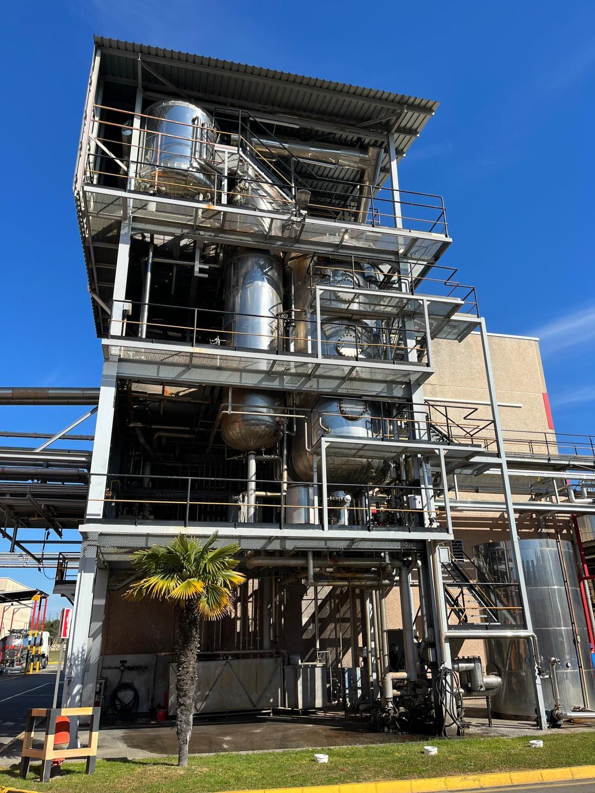 A large industrial building with a blue sky in the background.