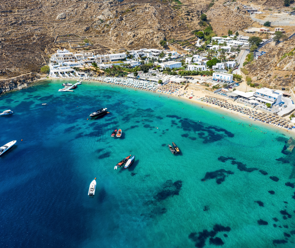 An aerial view of a beach with boats in the water