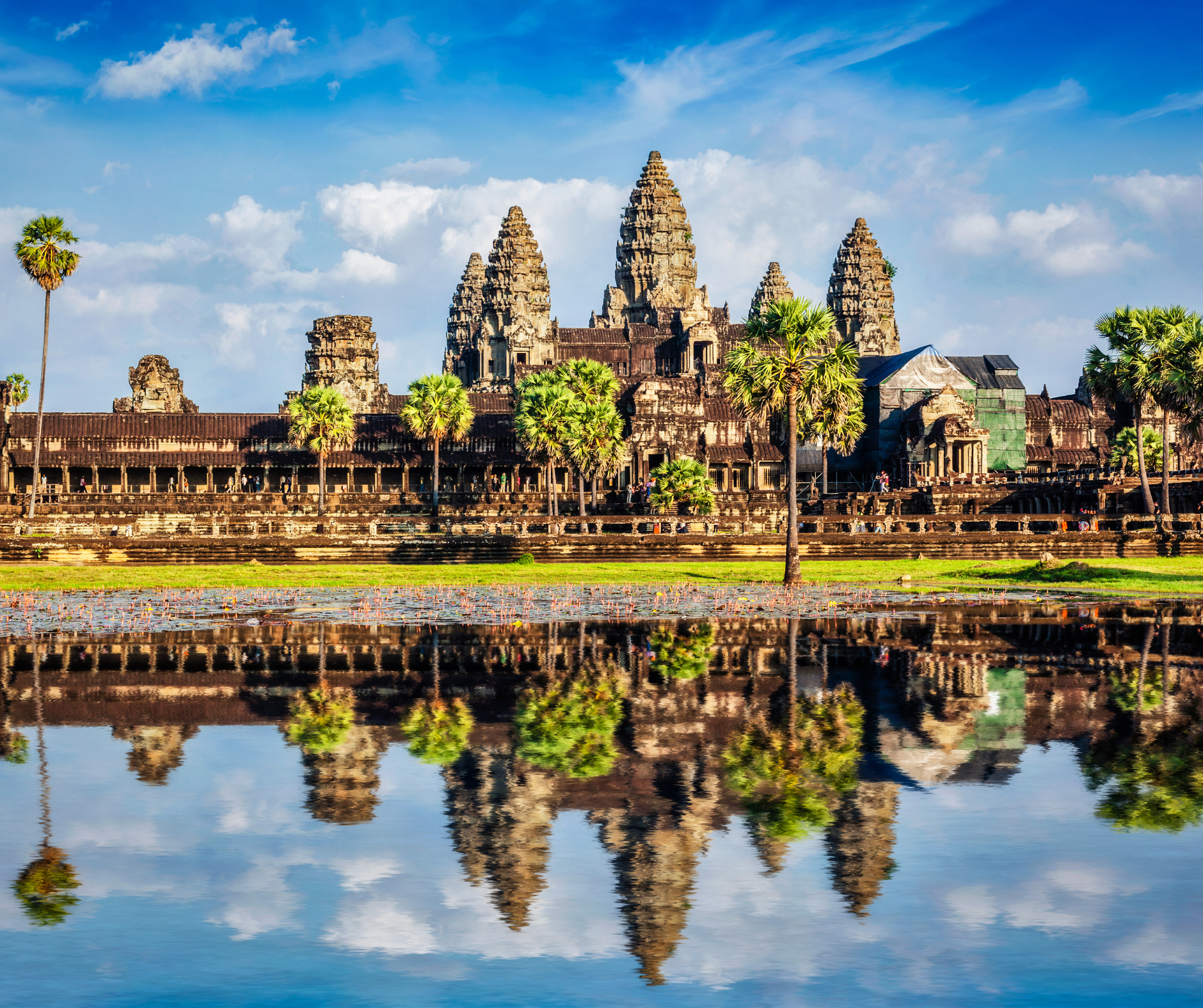 A large temple is reflected in a body of water.