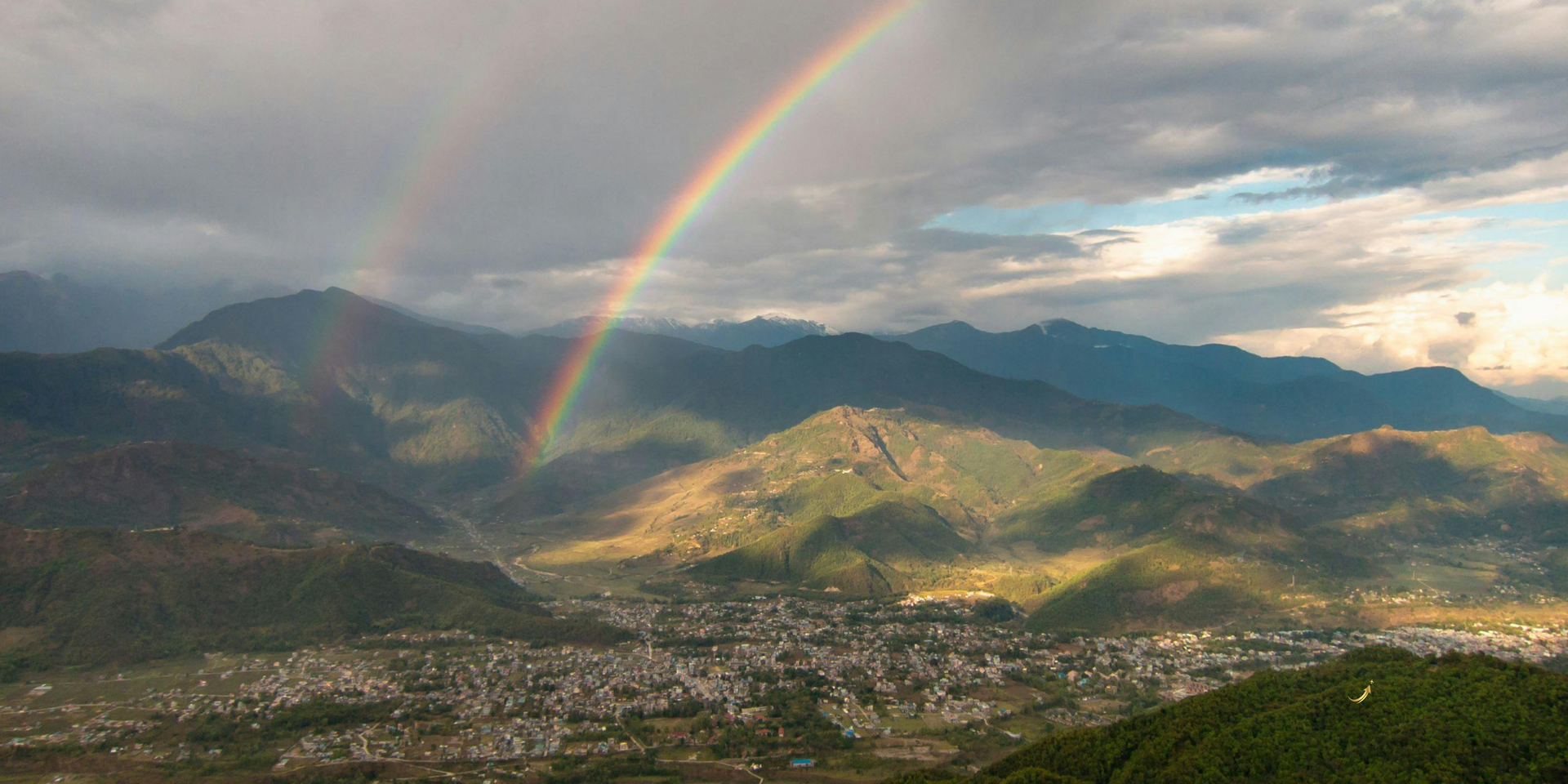 Rainbow appearing after rain over a lush landscape travel can still be beautiful in bad weather