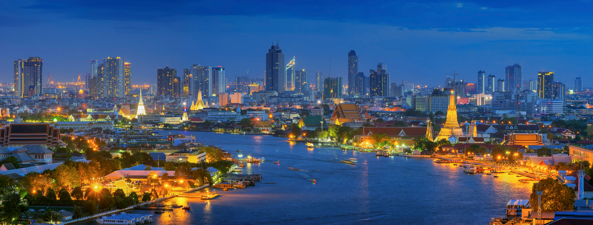 An aerial view of a city at night with a river in the foreground.