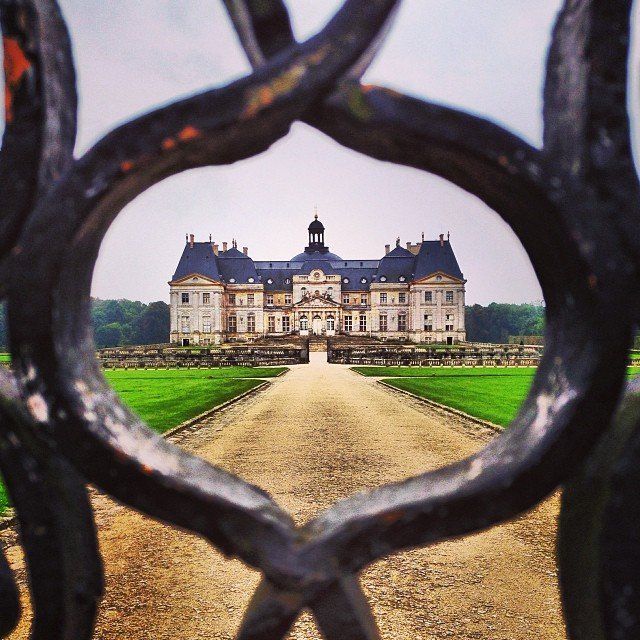 A view of a large castle through a fence