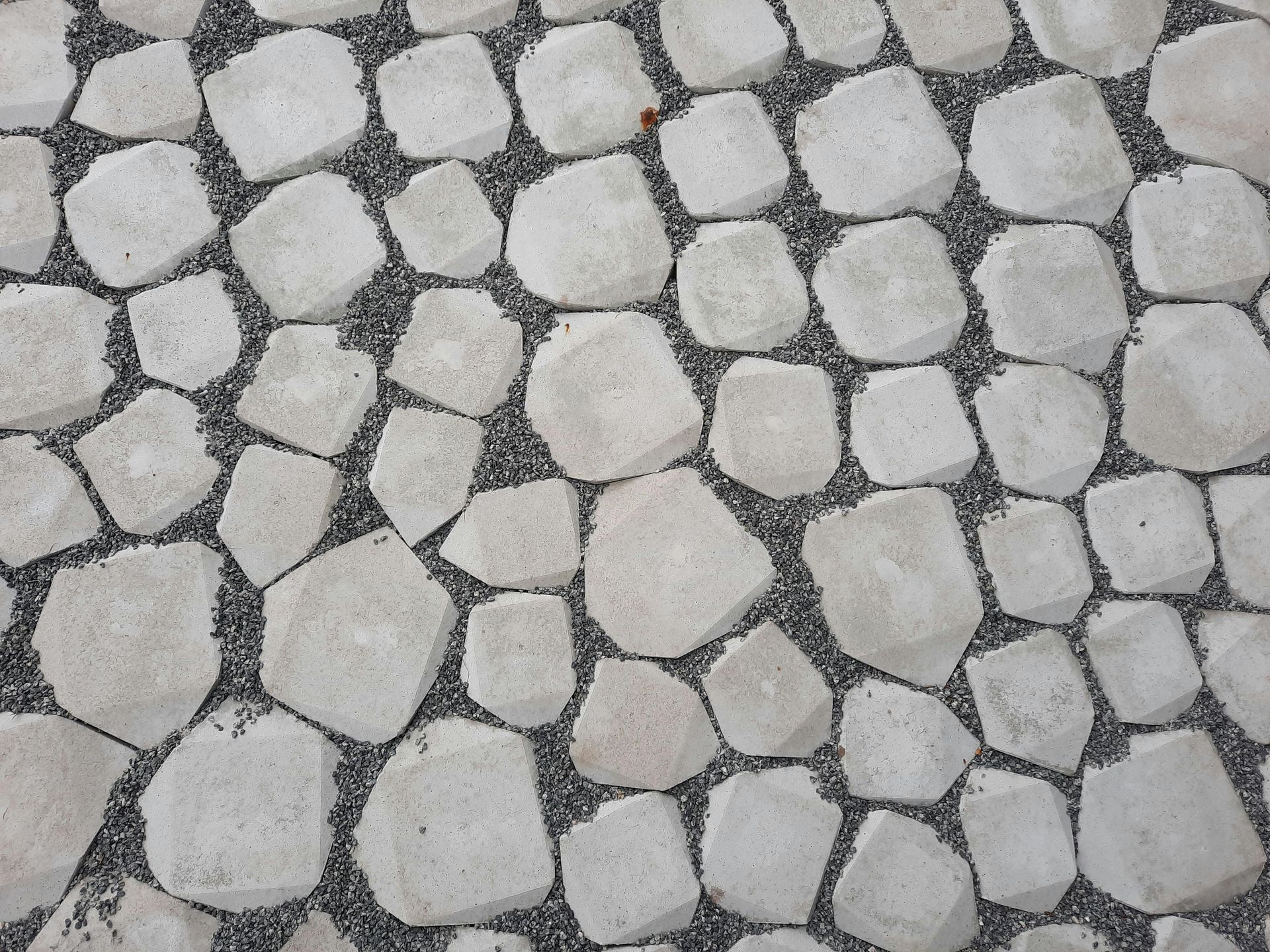 White, irregularly shaped stones arranged on a bed of dark gravel.