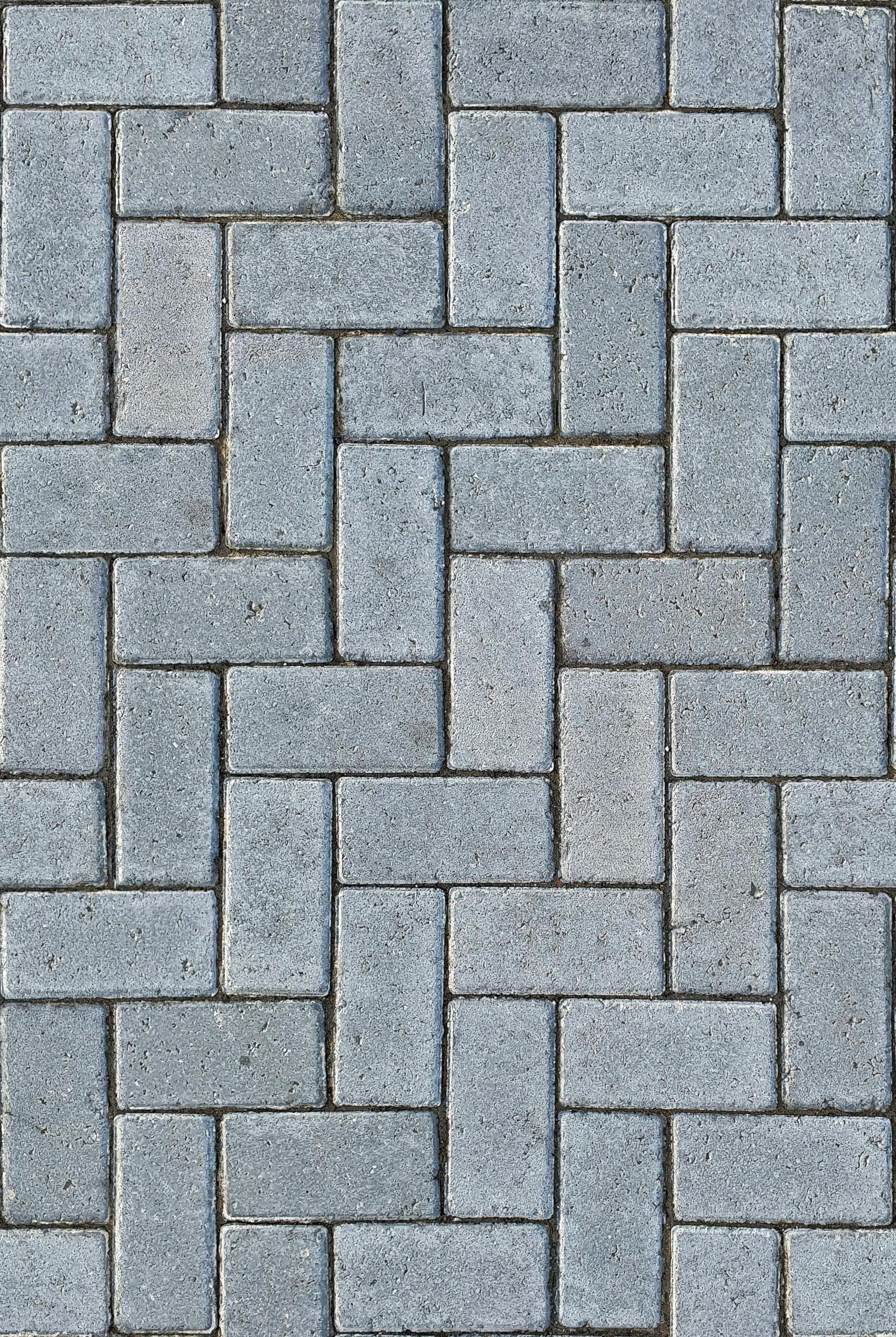 Gray interlocking brick pavement in a random, offset pattern.