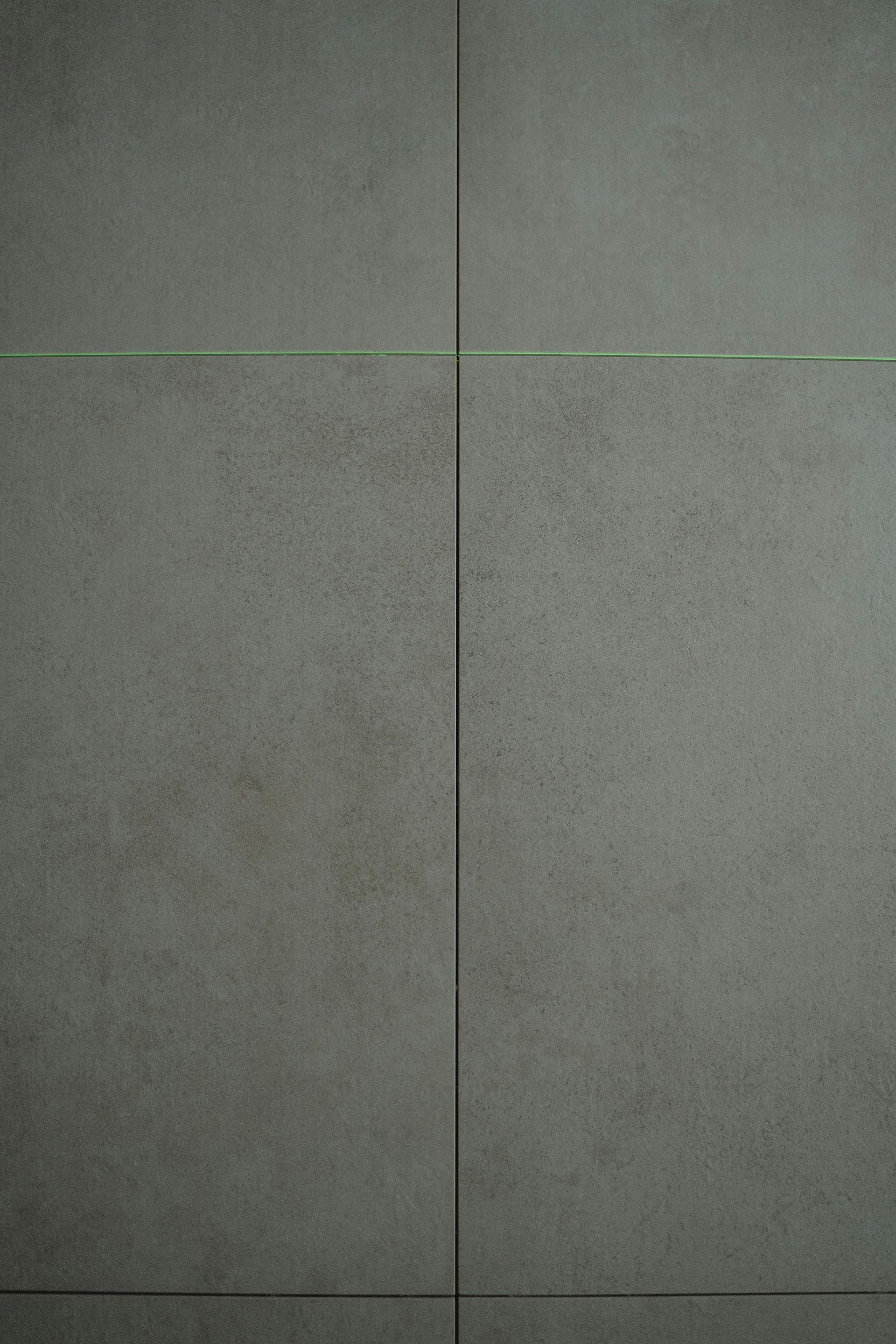 Close-up of gray tiled surface with thin, dark grout lines.