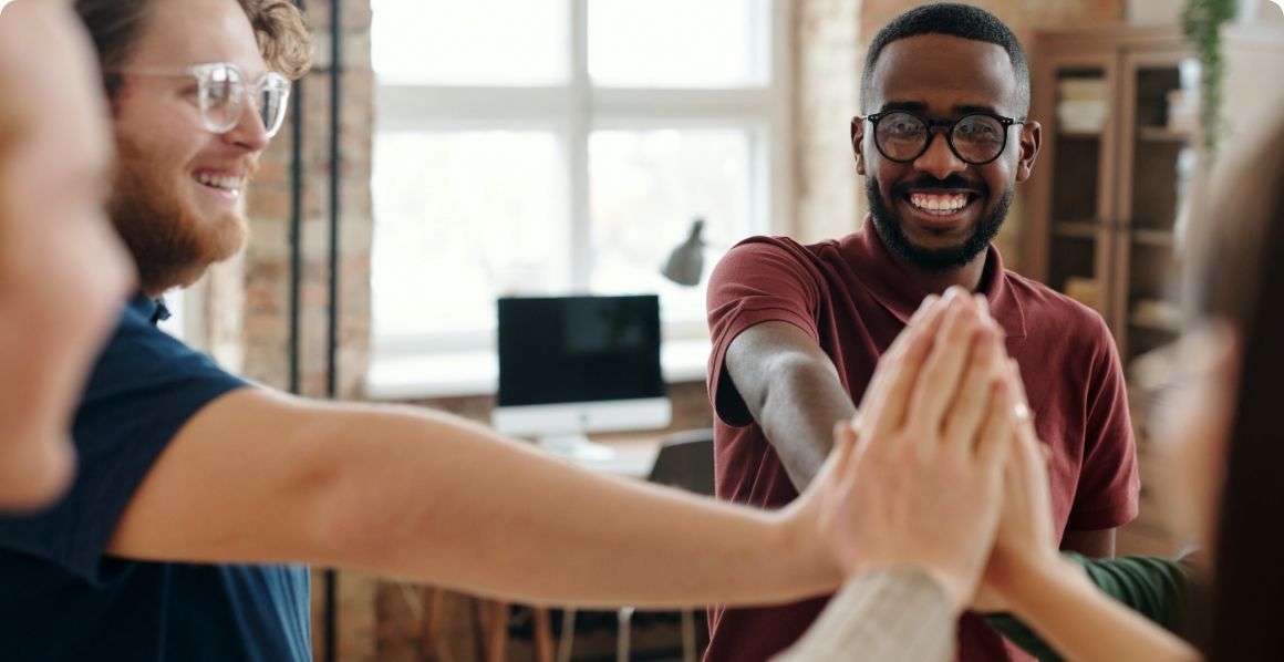Een groep mensen geeft elkaar een high five.