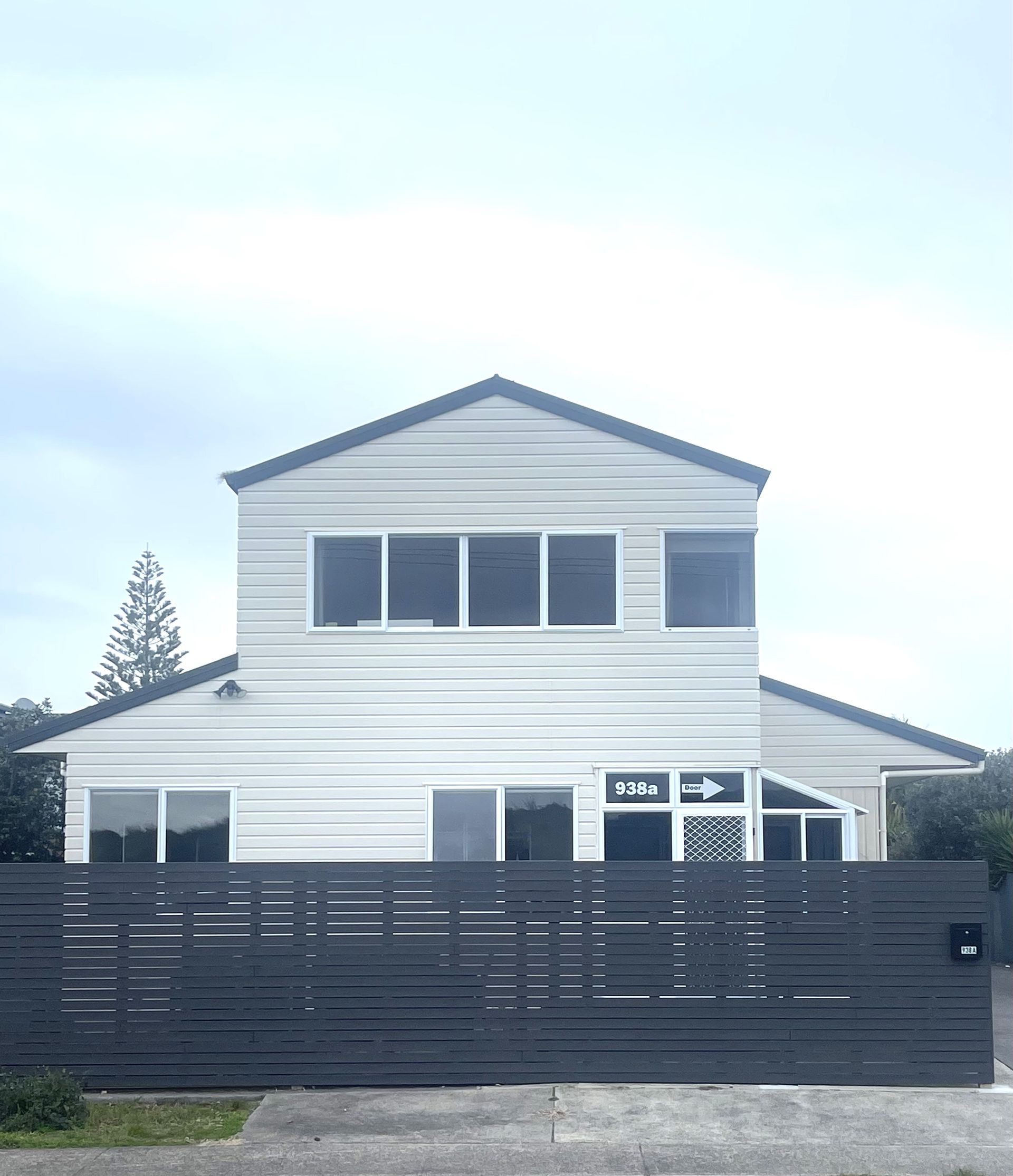 A white house with a black fence in front of it.