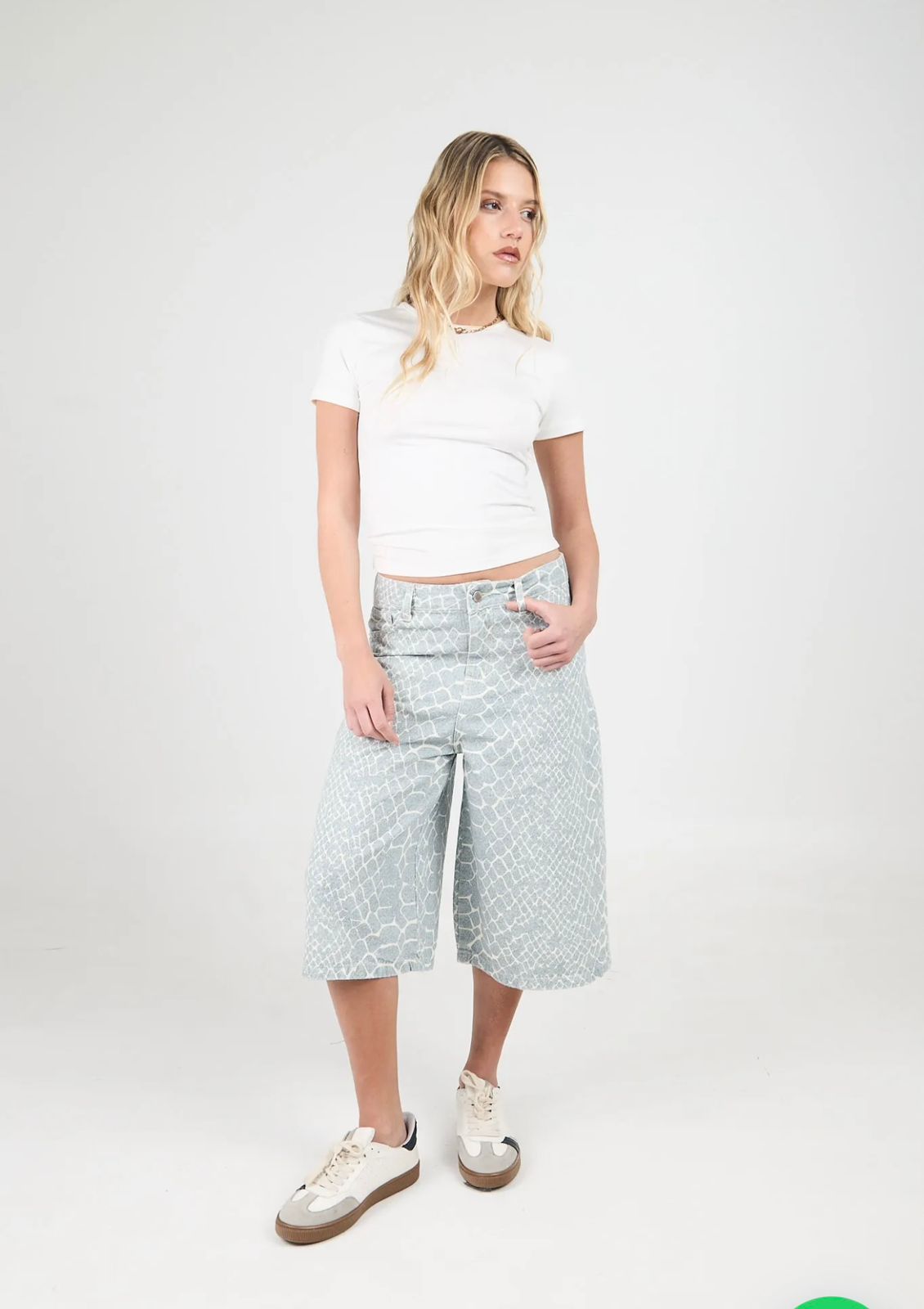 Mujer con pantalones culotte estampados y zapatillas deportivas.