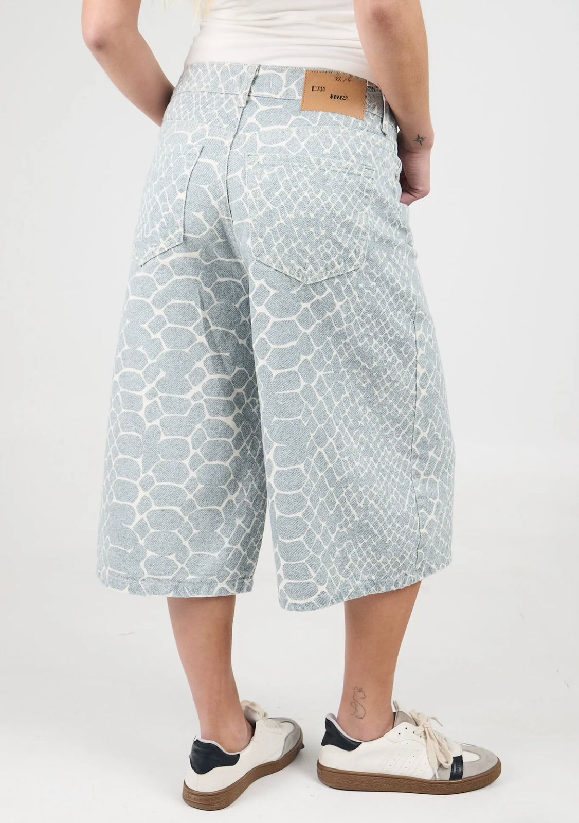 Mujer con pantalones culotte estampados y zapatillas deportivas.