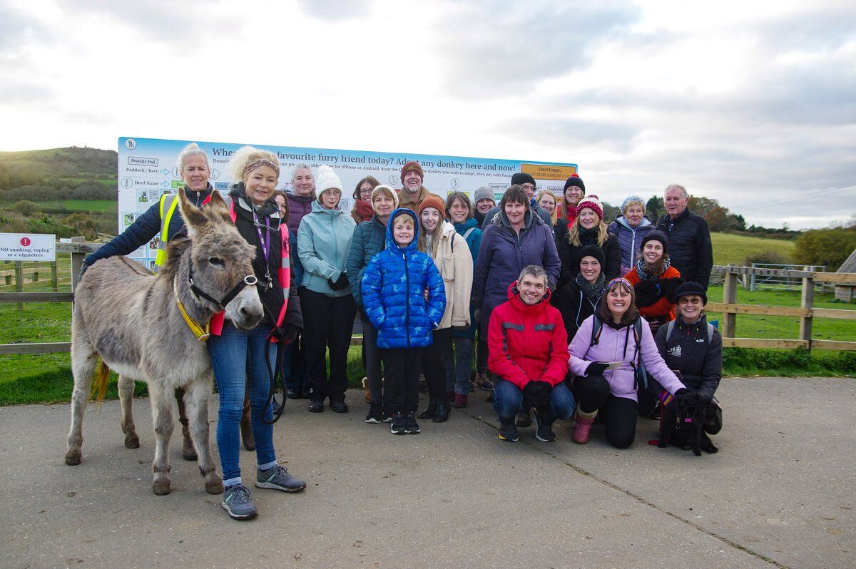 Group of people standing together with a donkey at the Isle of Wight Donkey Sanctuary