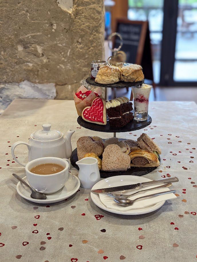 A display of afternoon tea food with a teapot and mug.