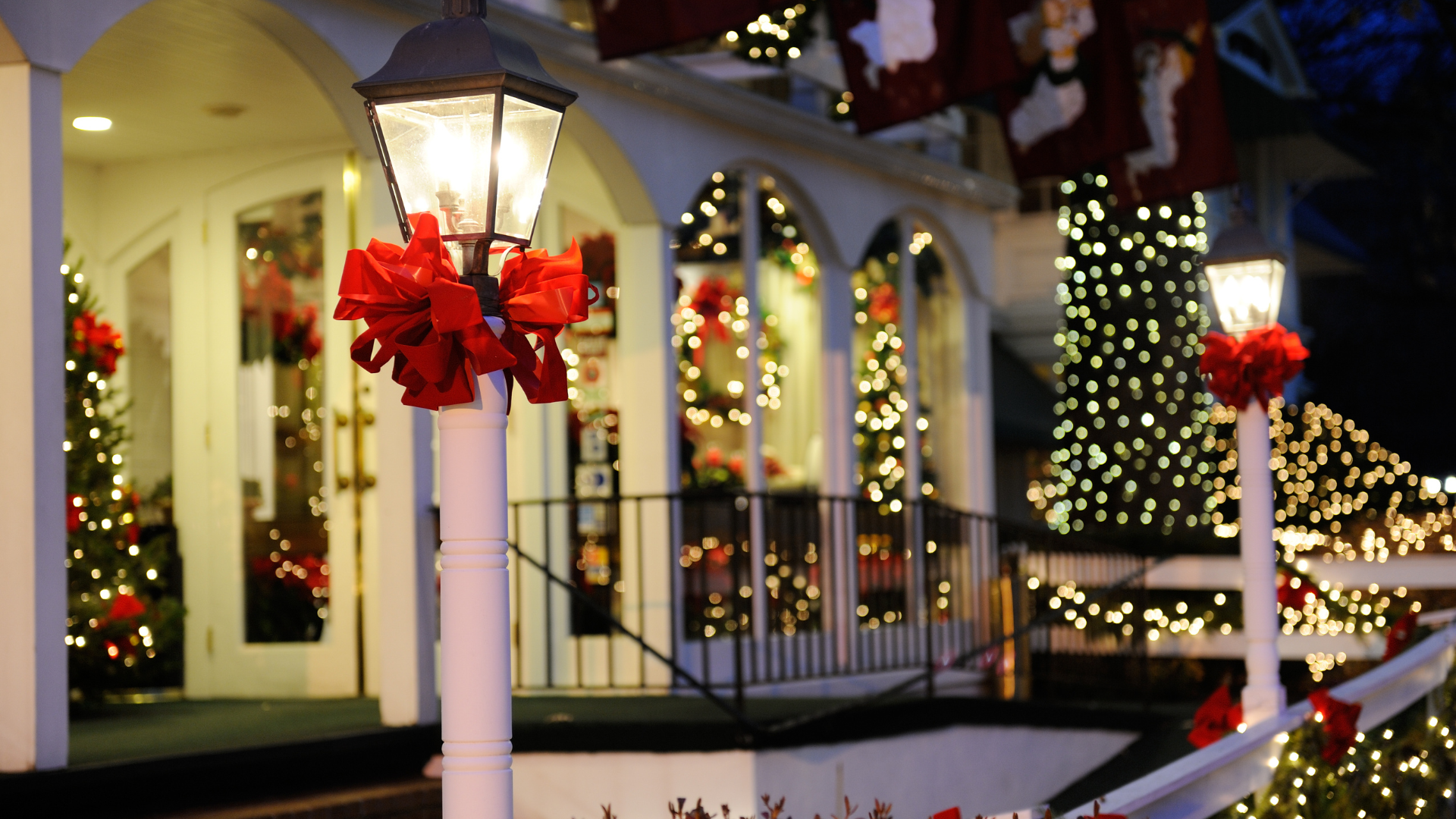 Exterior of a building decorated for Christmas with lights and red bows on lampposts.