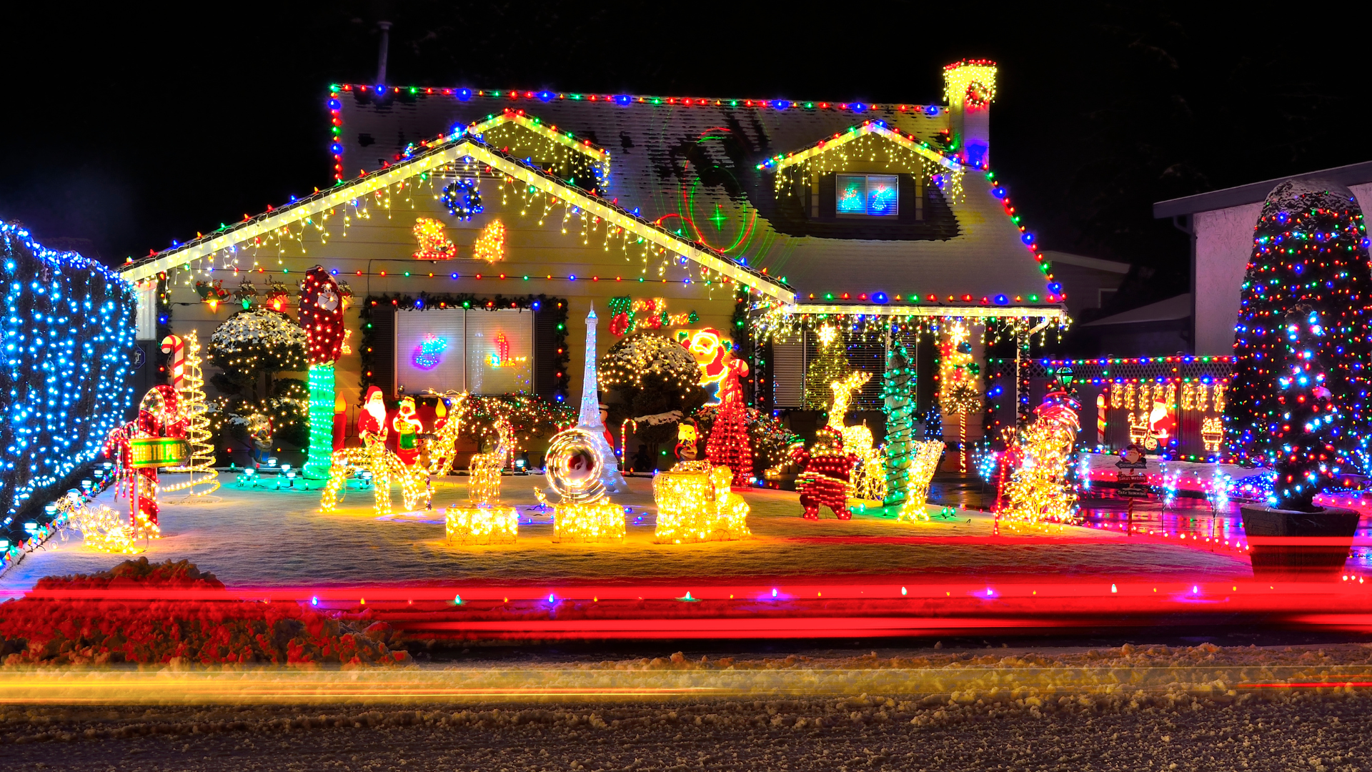 House brightly decorated with Christmas lights, including a red, blue, and green color scheme.
