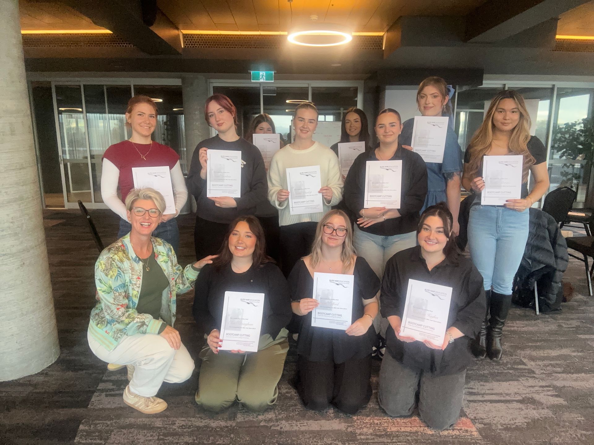 A group of Elite Hair Education Workshop students with their certificates after completion.