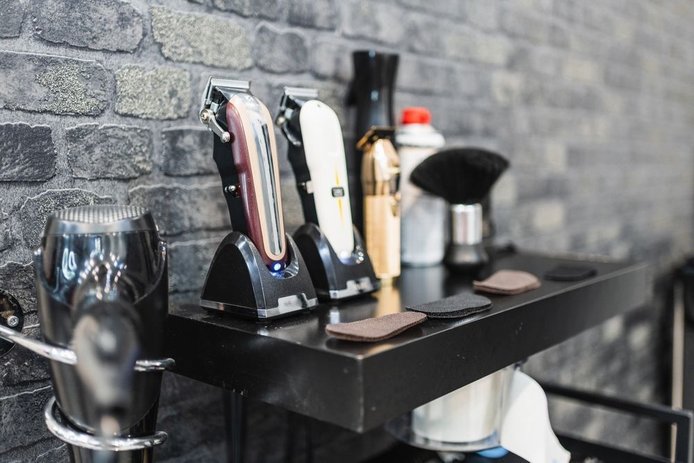 A table with a bunch of hair clippers on it in a barber shop.