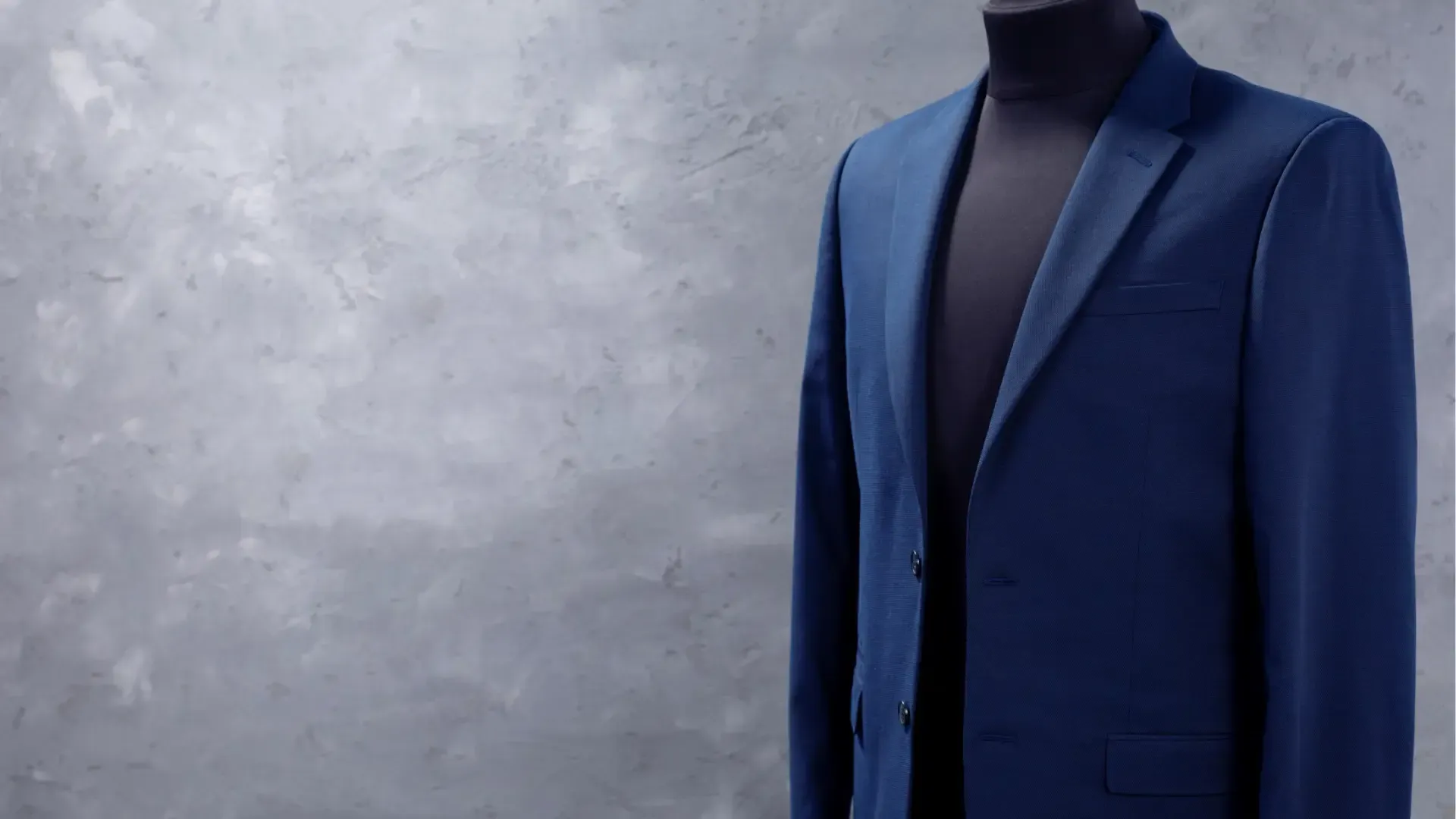 A blue suit jacket is on a mannequin.