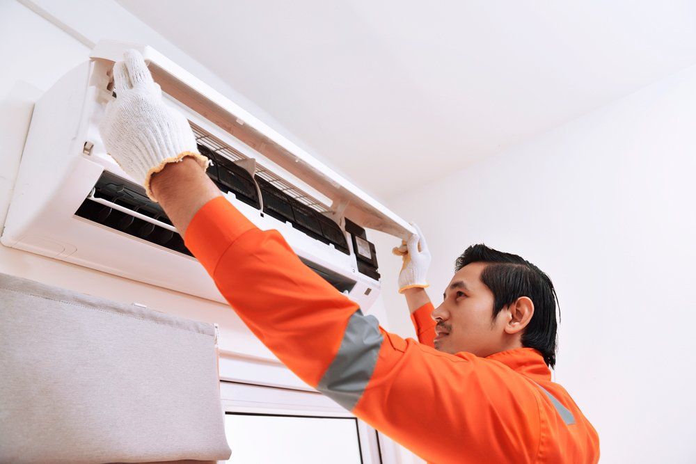 Man Installing Air Condition — South Bend, IN — Ernsperger Air Conditioning & Heating Inc