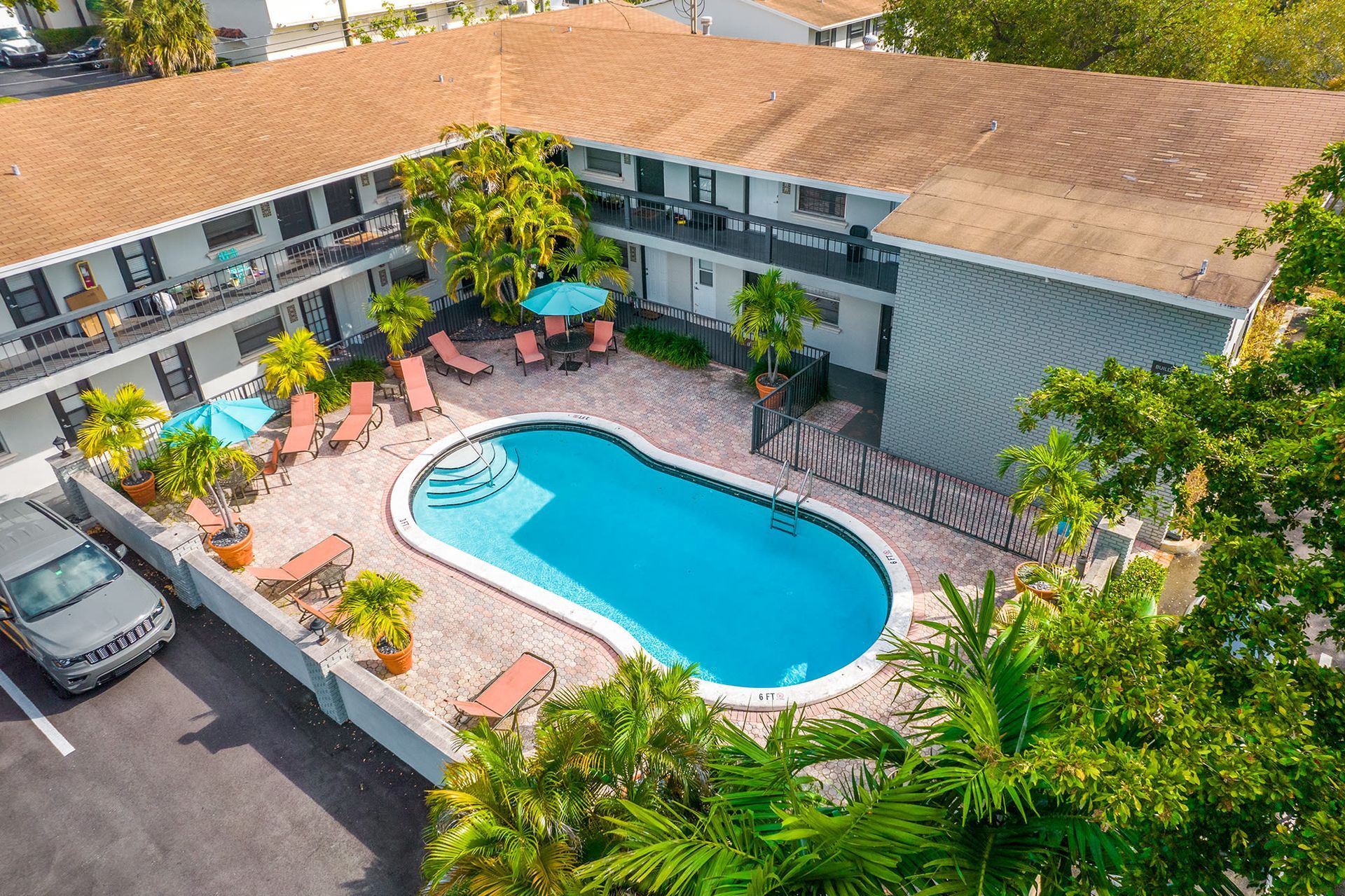Aerial view of a communal pool area with lounge chairs and umbrellas.