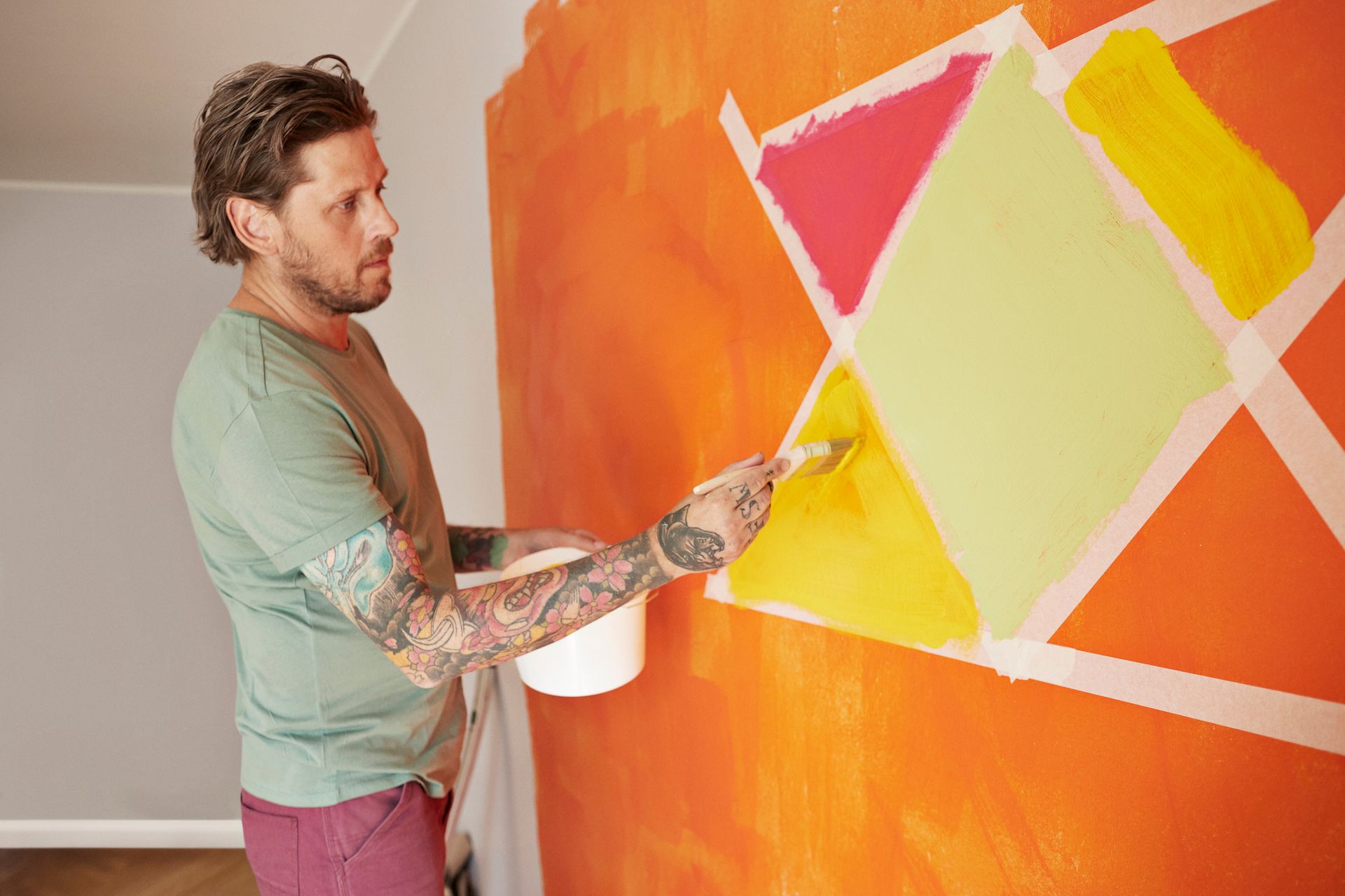 A man is painting a wall in pattern.