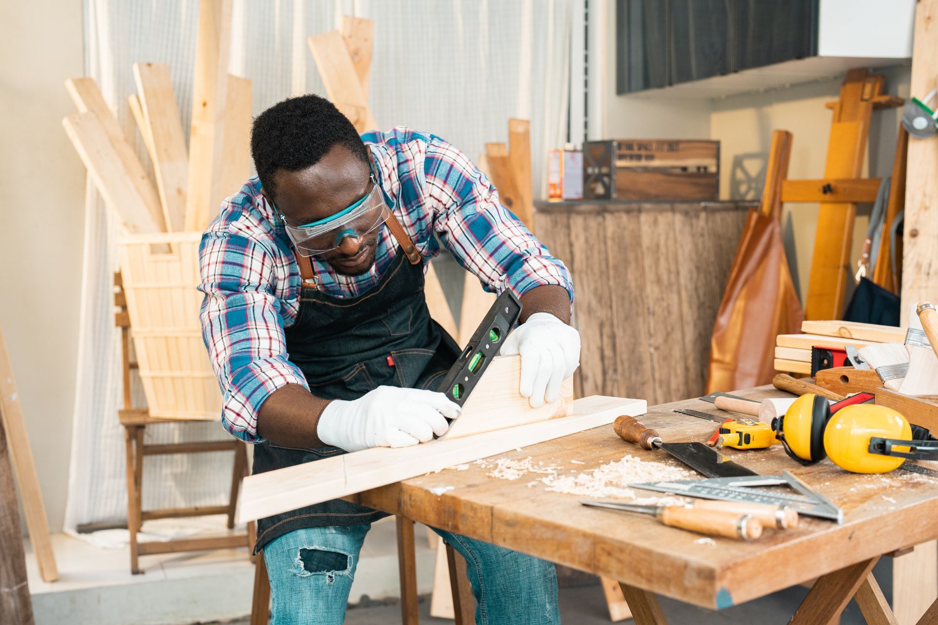 A man is working on a piece of wood in a workshop.