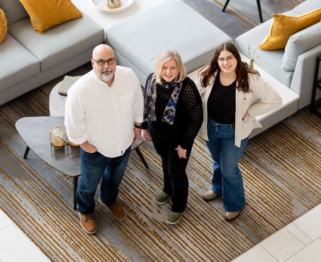 A group of people standing next to each other in a living room.