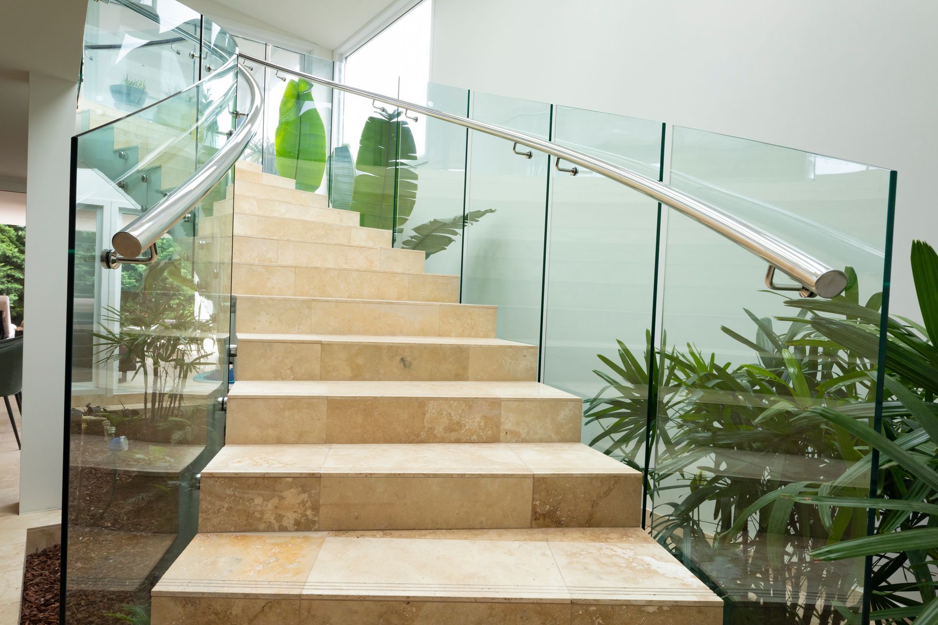 Travertine Pattern Tiled Staircase Leading Up Surrounded By  Plants With Glass Balustrades And Metal Railings  — Star Glass Design Pty Ltd in Mayfield, NSW