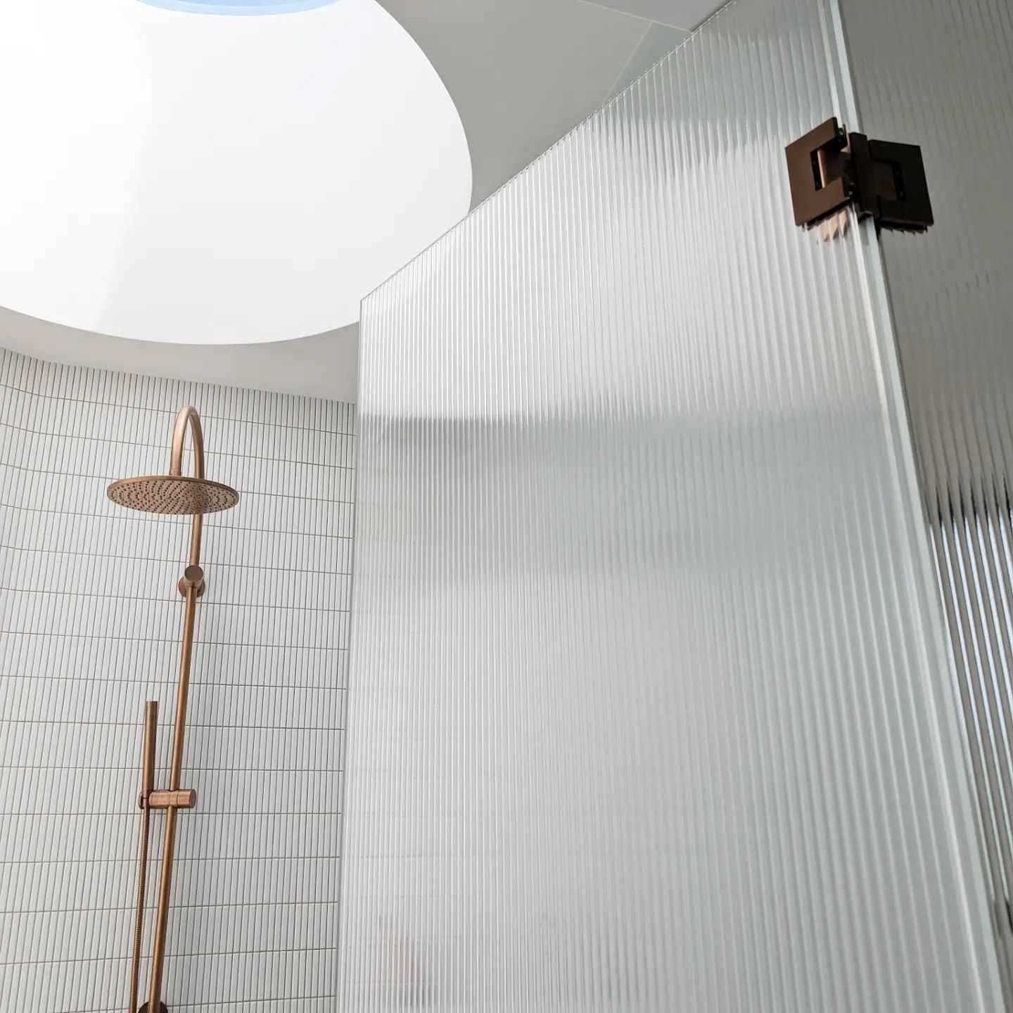 A Shower with Fluted Glass and a Brass Overhead Shower Head — Star Glass Design Pty Ltd in Mayfield, NSW