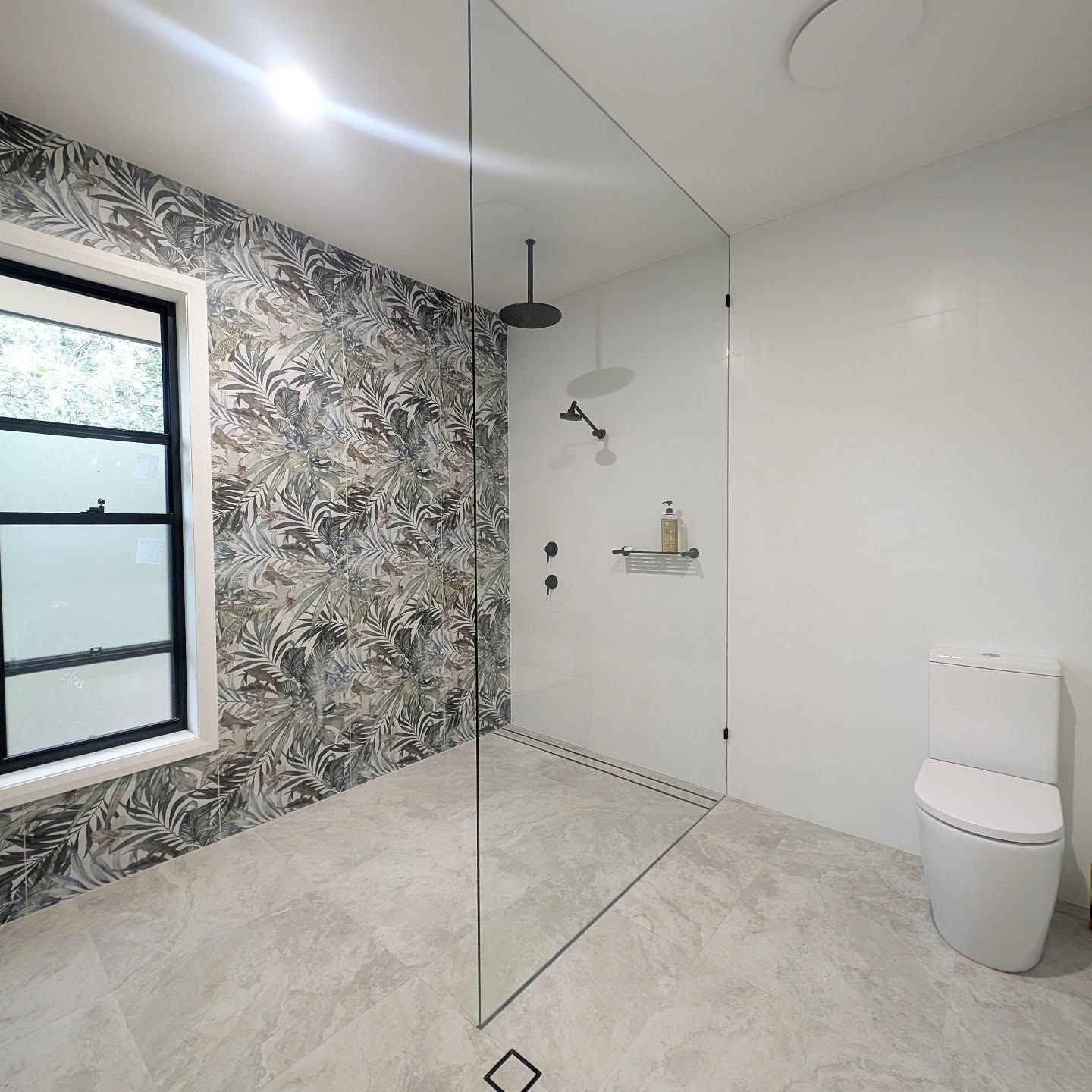 Bathroom With Large Open-Air Shower And Rainfall Shower Head With Black And White Jungle Pattern Tiling — Star Glass Design Pty Ltd in Mayfield, NSW