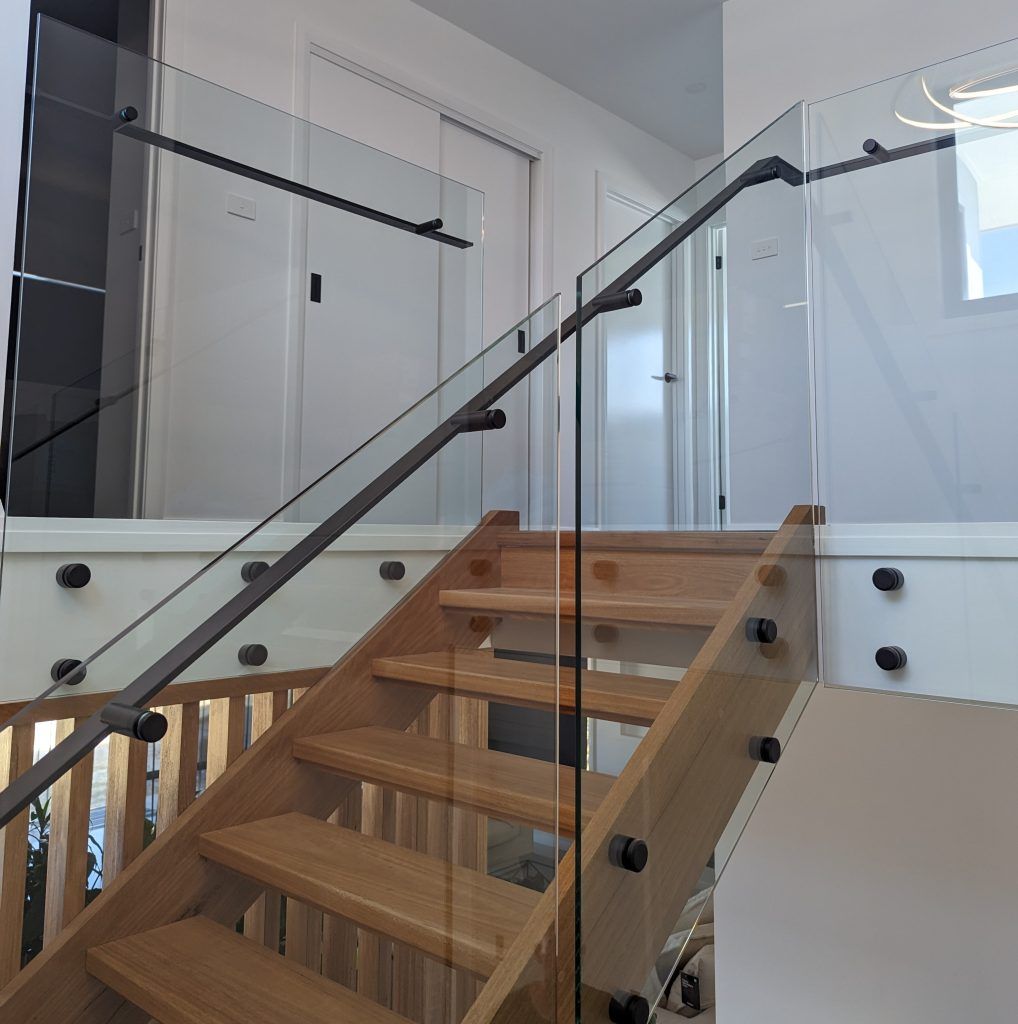 A Wooden Staircase with A Clear Glass Railing — Star Glass Design Pty Ltd in Mayfield, NSW