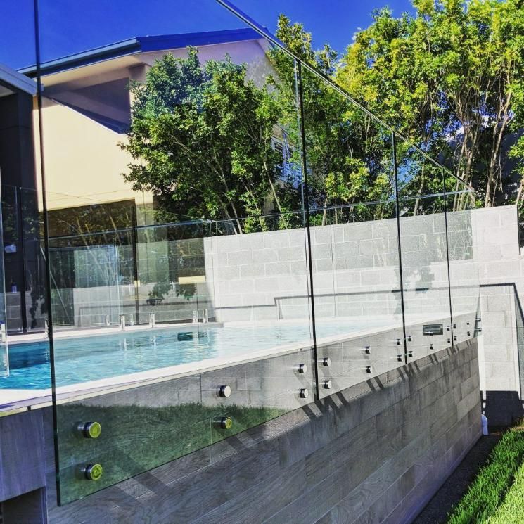 A Swimming Pool with A Glass Fence Around It — Star Glass Design Pty Ltd in Mayfield, NSW