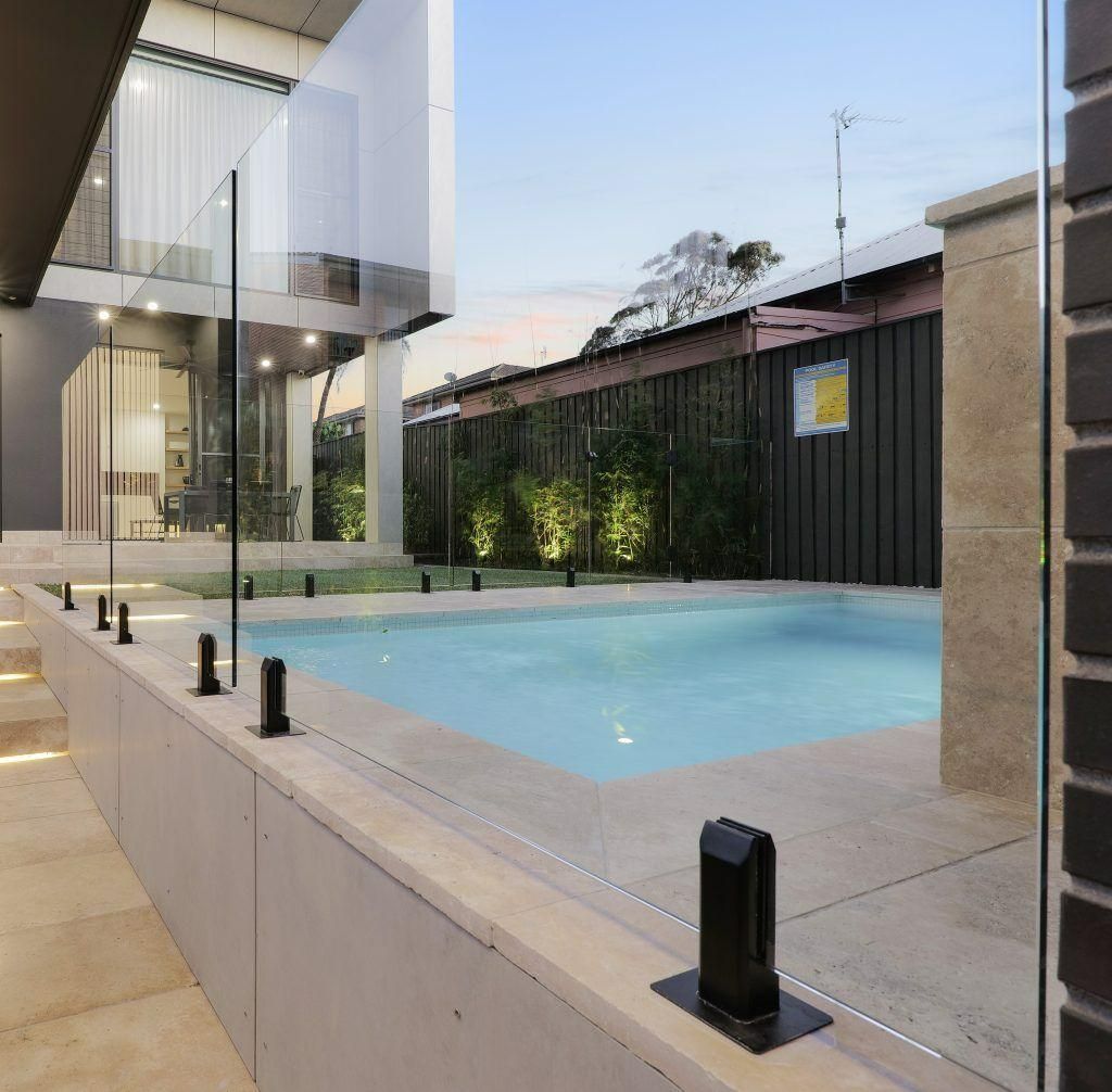 A Large Swimming Pool Is Surrounded by A Glass Fence — Star Glass Design Pty Ltd in Mayfield, NSW