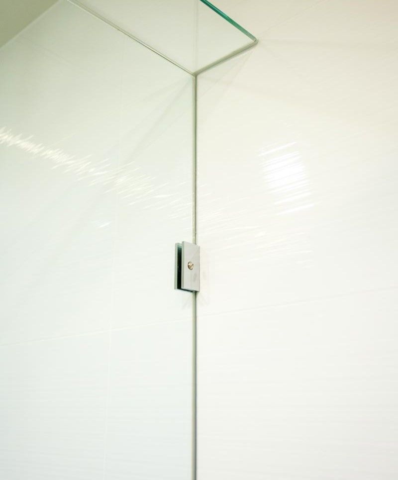 A Close up Of a Glass Shower Door with A White Wall Behind It — Star Glass Design Pty Ltd in Mayfield, NSW