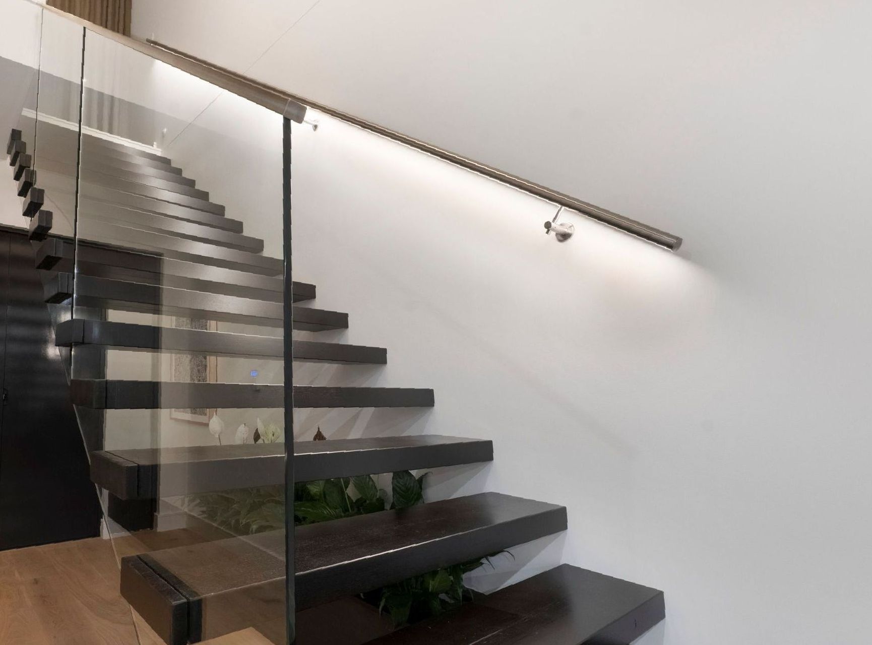Floating Staircase With Inlaid Railing LED Lights Made From Dark Timber In A House — Star Glass Design Pty Ltd in Mayfield, NSW