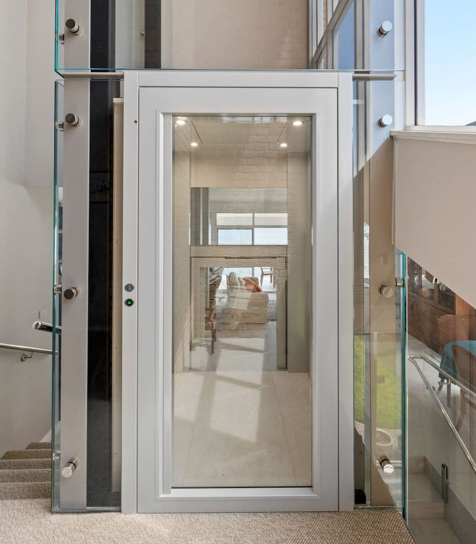 An Elevator With A Glass Door And Stairs In A Building — Star Glass Design Pty Ltd in Mayfield, NSW