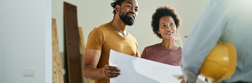 young couple holding surveyor plans