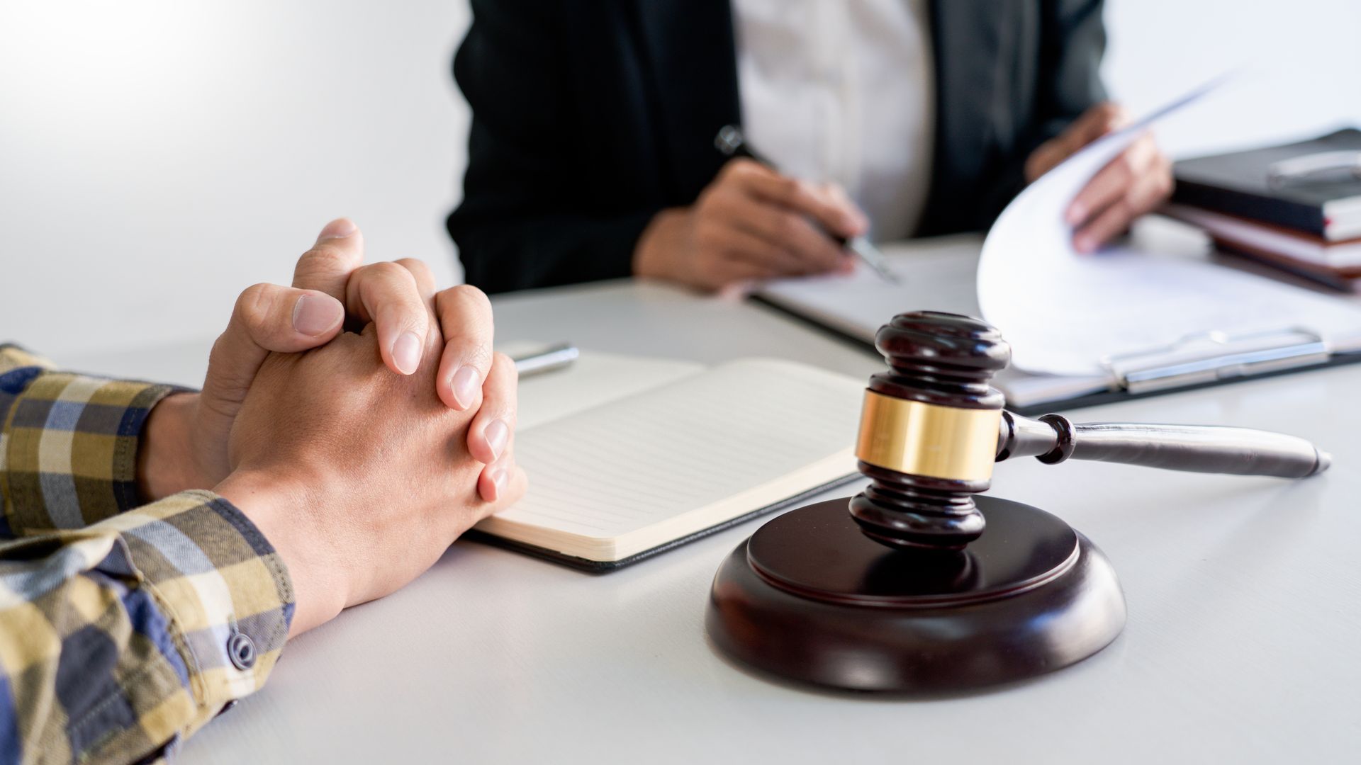 A close-up of an attorney consulting a client in his office while looking through paperwork.