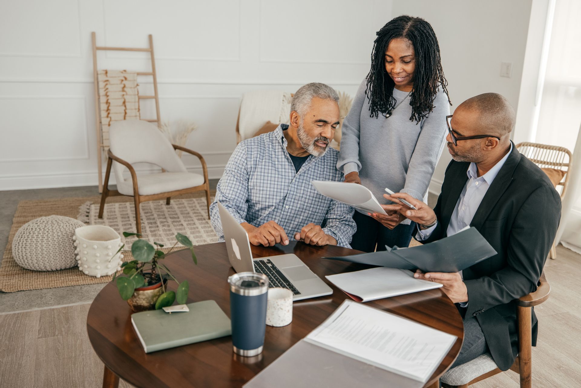 Estate planning attorney with two clients at their home explaining documentation.