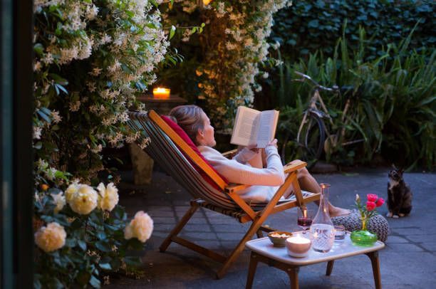 A Woman Is Sitting in a Chair Reading a Book — Lakeland, FL — Thomason Furniture & Mattress