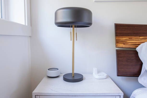 A Lamp Is Sitting on a Nightstand Next to a Bed — Lakeland, FL — Thomason Furniture & Mattress