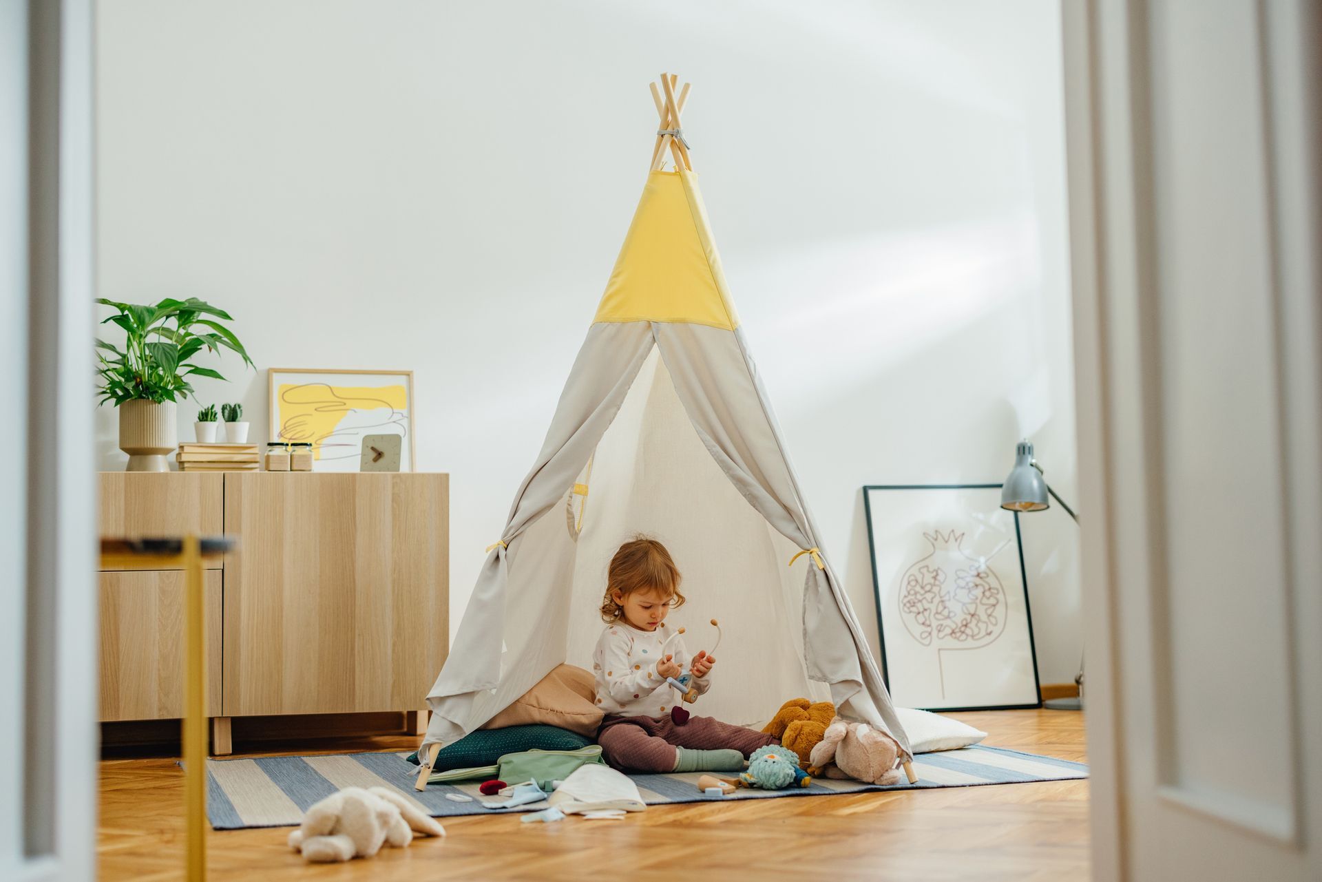 A Little Girl Is Sitting in a Teepee in a Living Room — Lakeland, FL — Thomason Furniture & Mattress