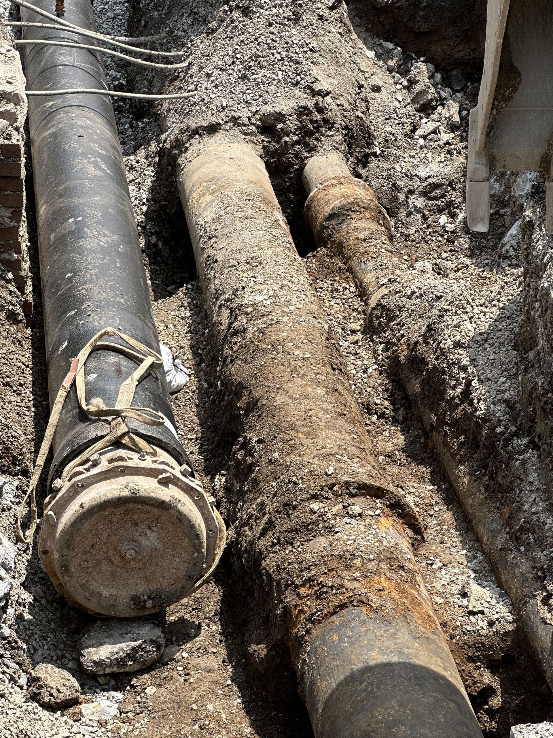 A couple of pipes are laying in the dirt.