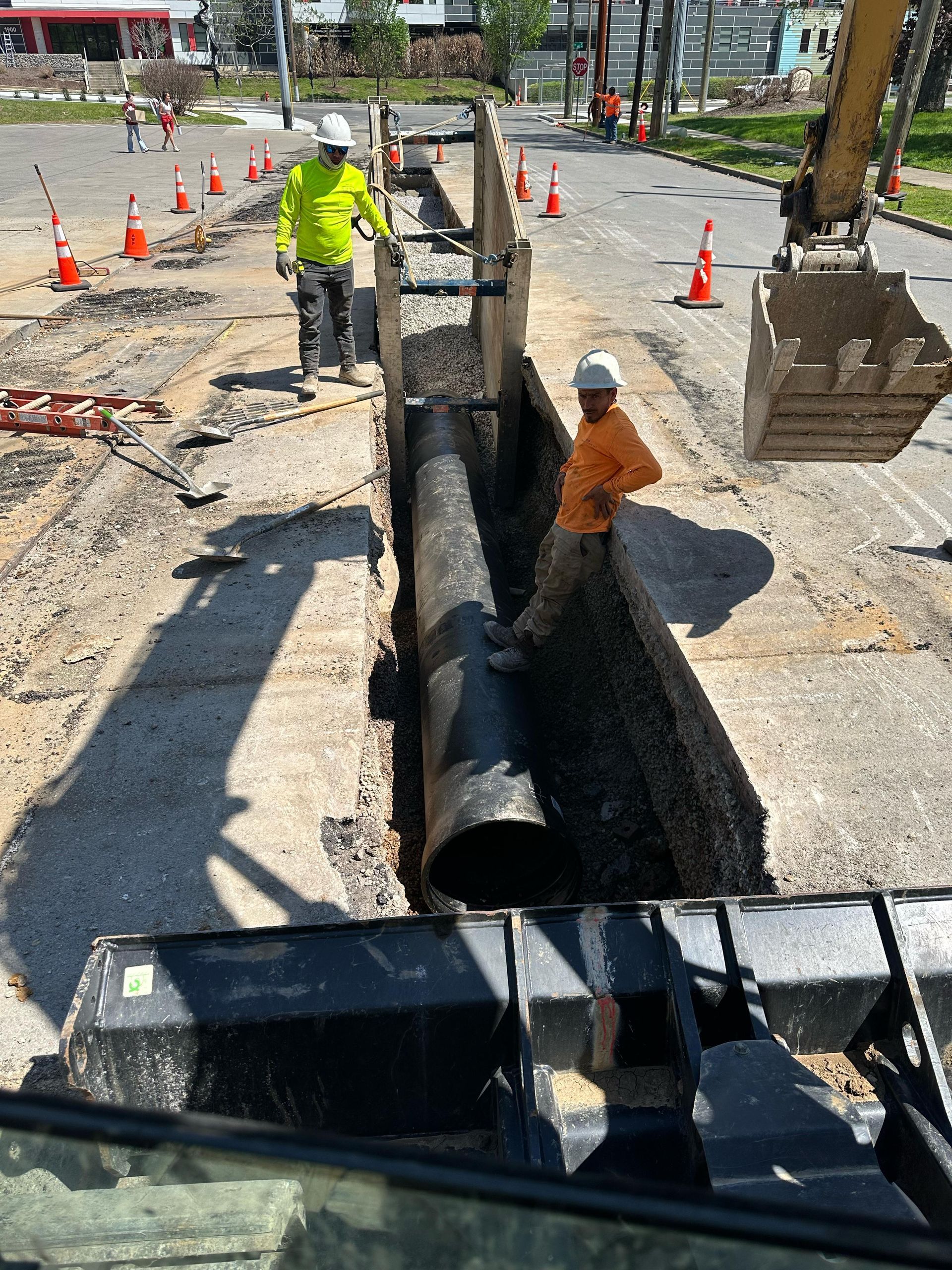 A man is standing next to a large pipe on a construction site.
