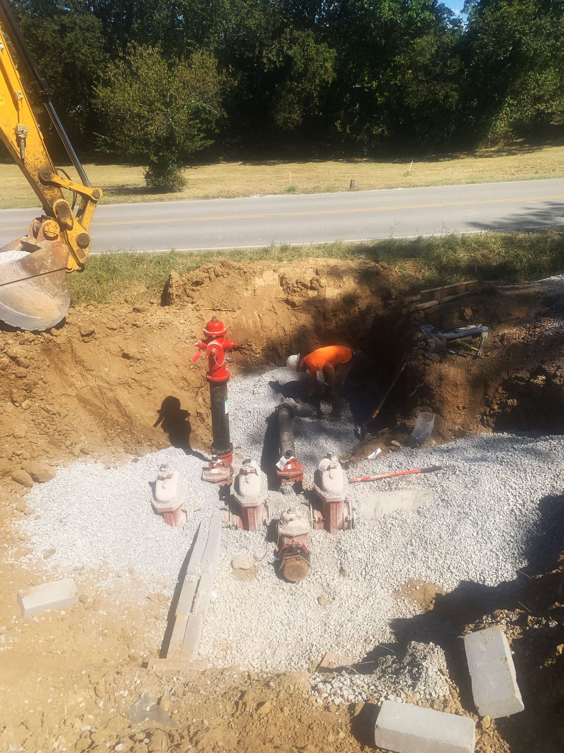 A man is working on a fire hydrant in the dirt.