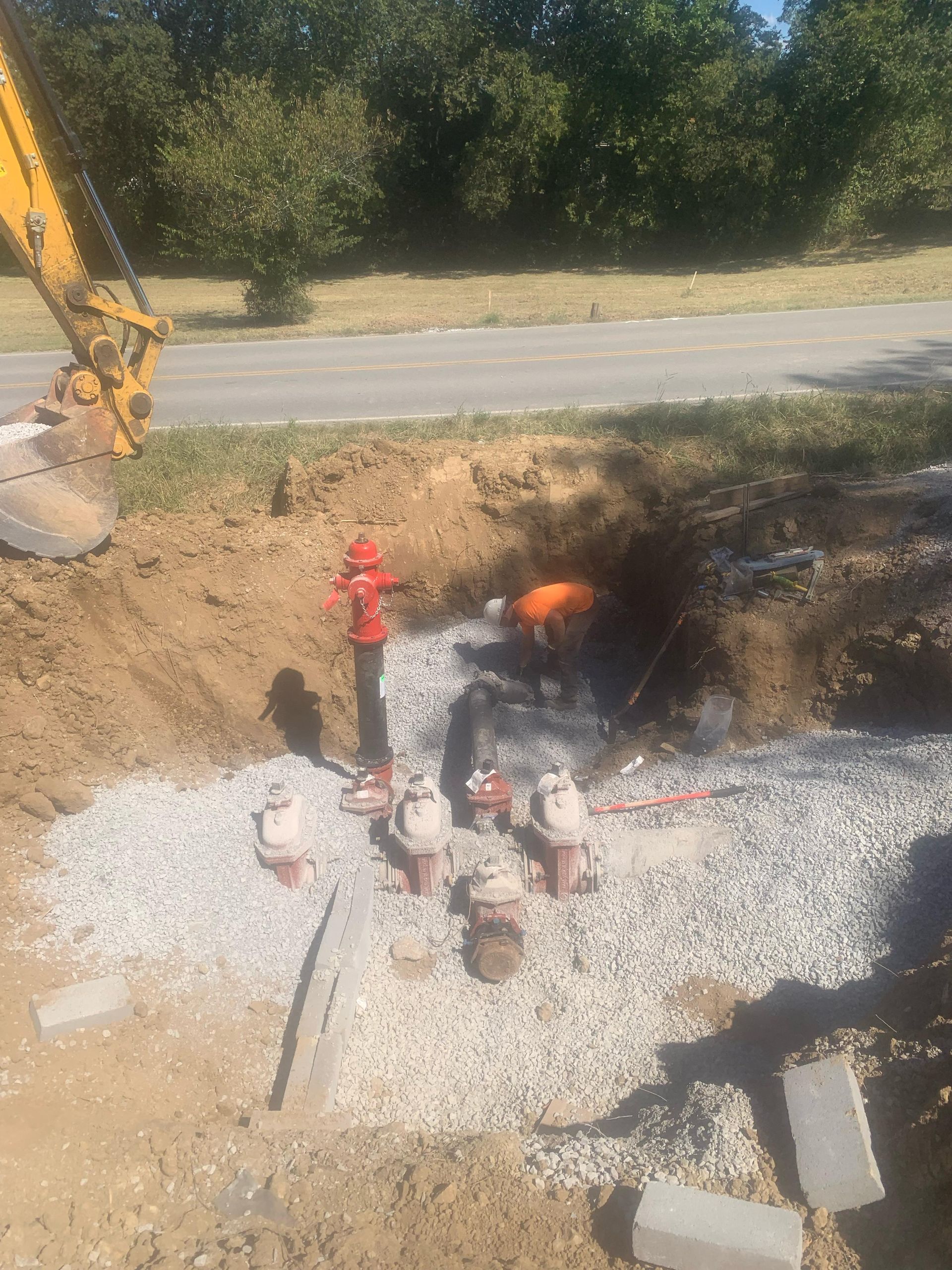 A man is working on a fire hydrant in the dirt.