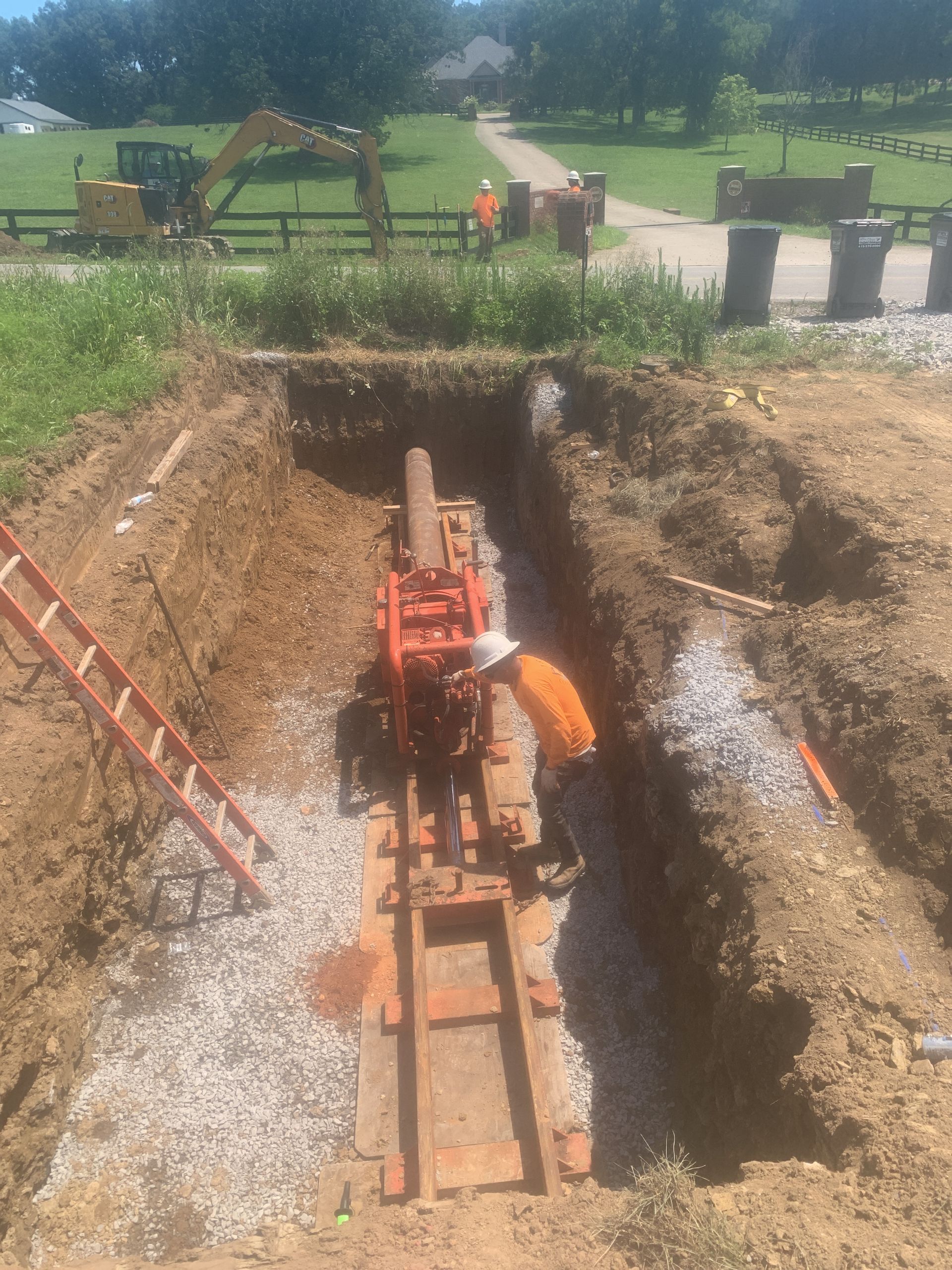 A man is working on a machine in a hole in the ground.