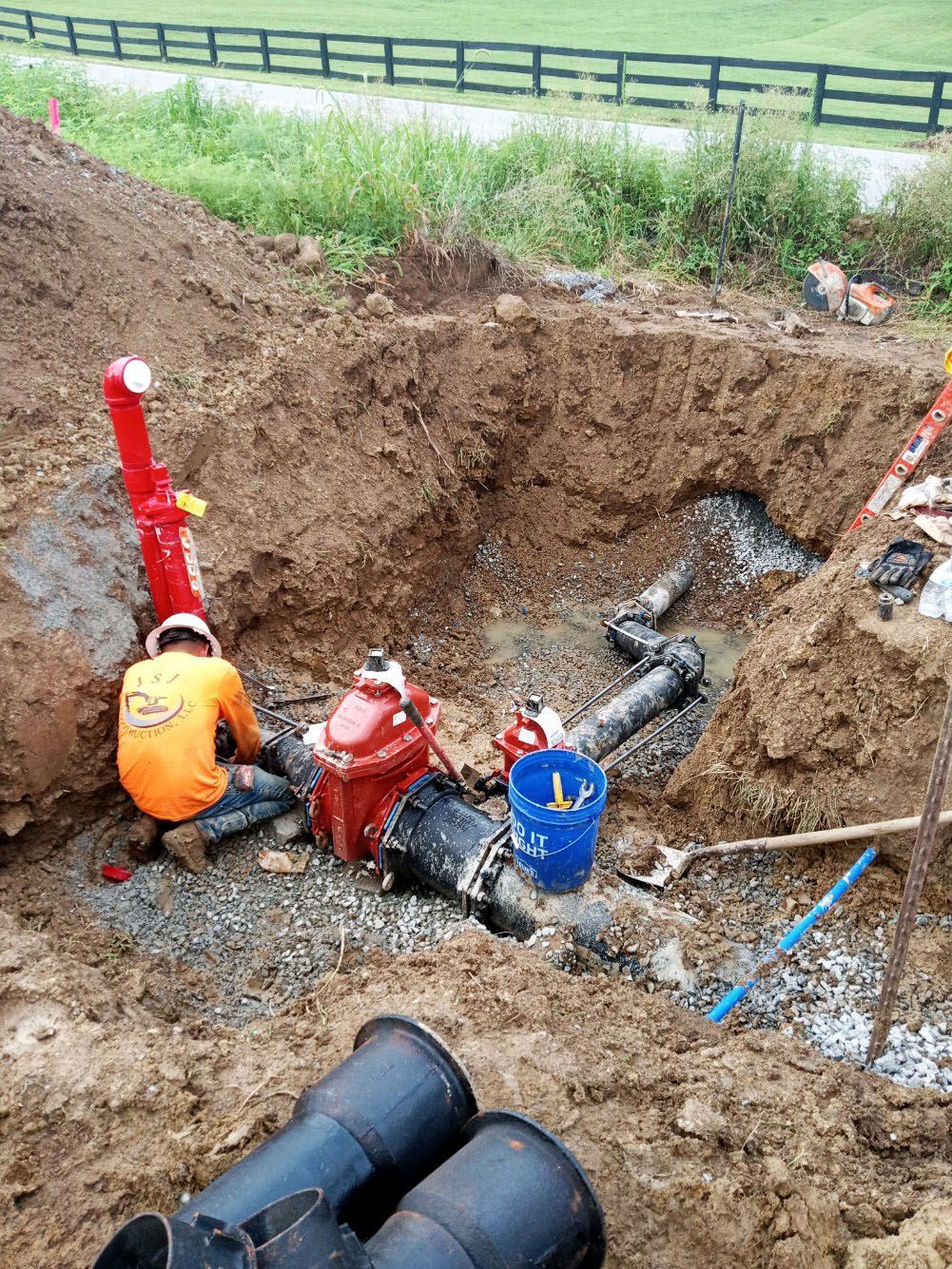 A man is working on a fire hydrant in the dirt.