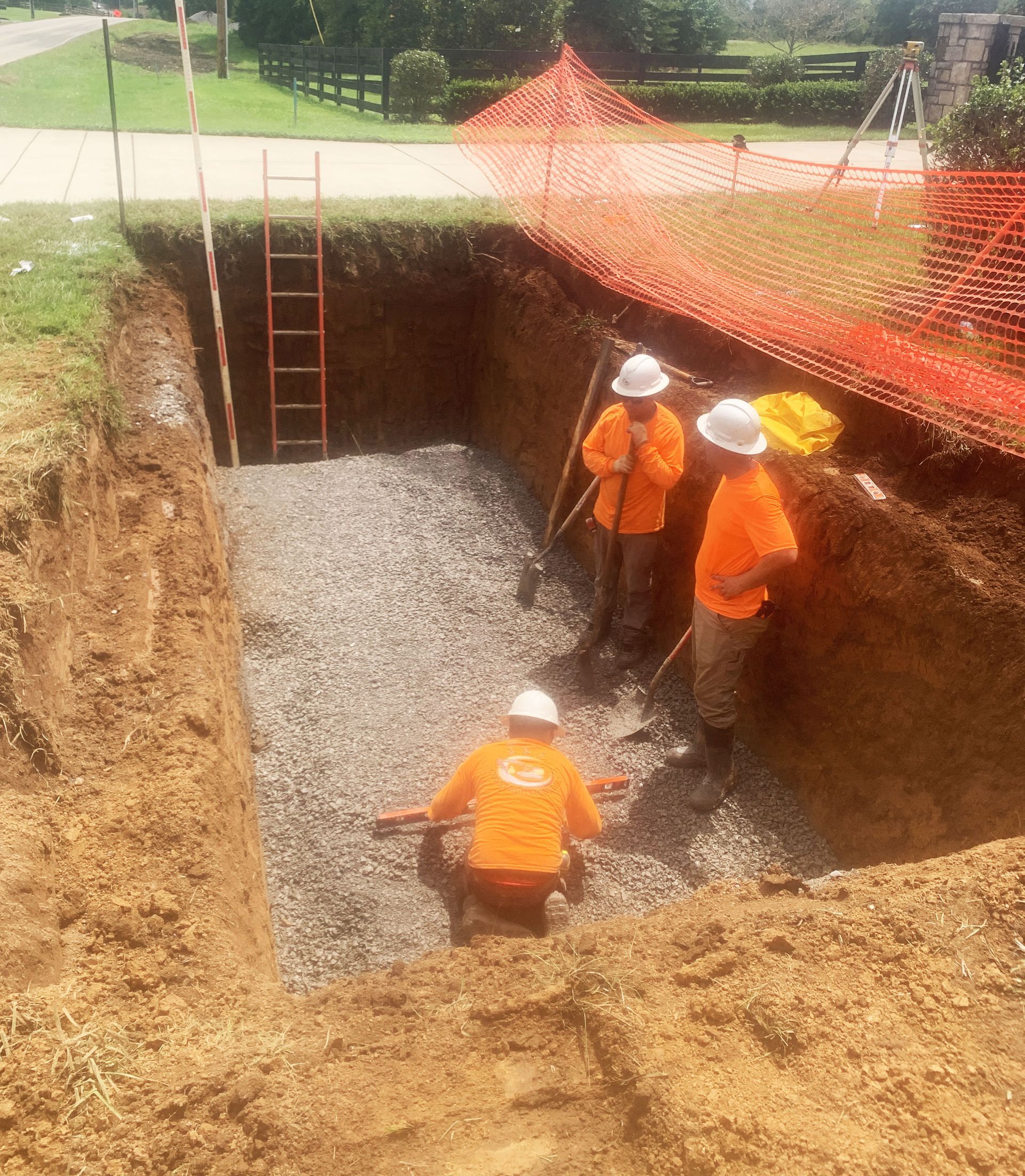 A group of construction workers are digging a hole in the ground.