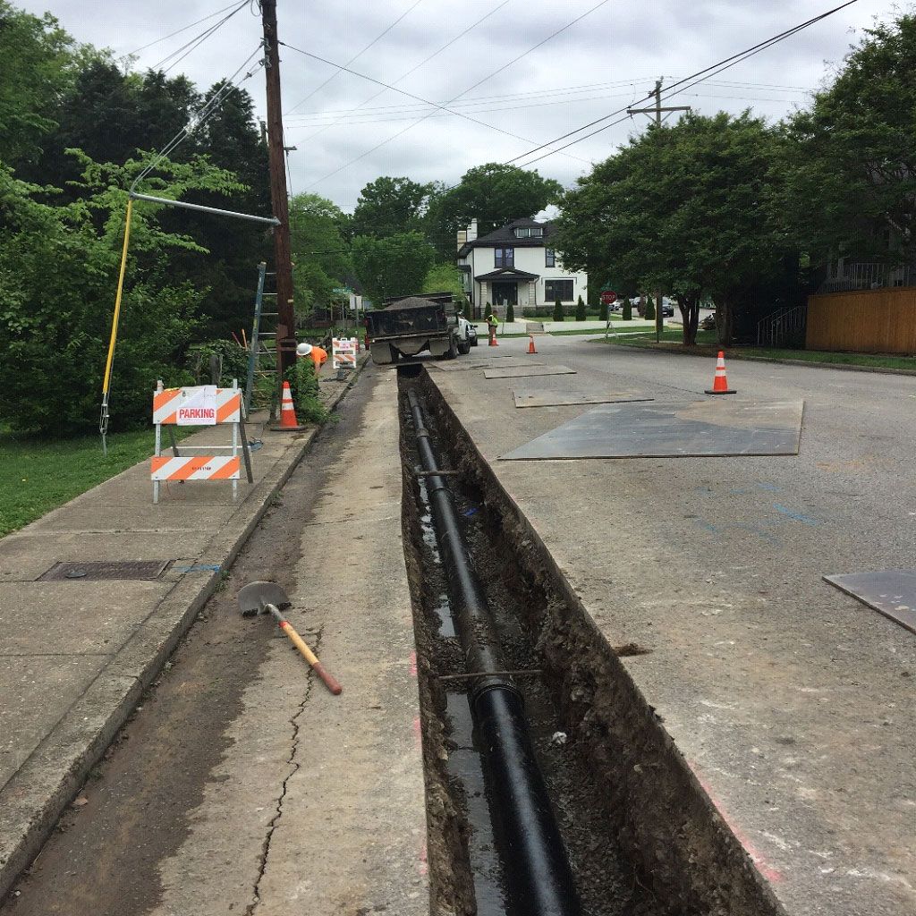 A trench is being dug in the side of the road